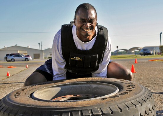 Senior Master Sgt. Chris McKinney, 46th Weather Squadron, lifts a fire truck tire during the first sergeants vs commanders’ challenge Oct. 7 at Eglin Air Force Base, Fla.  The challenge represented the physical training course new Airmen must accomplish to become Air Force firefighters.  The course included hose carrying, dragging and pulling, victim carry and climbing 10 steps up a ladder five times and more.   The shirts beat the commanders for a second year by a full minute with a combined time of 18 minutes, 11 seconds.   (U.S. Air Force photo/Samuel King Jr.)