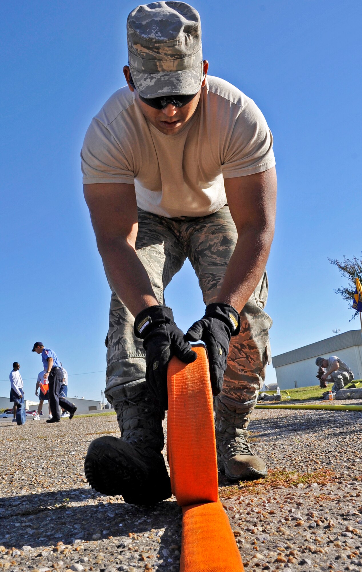 Senior Airman Eric Kautz, 96th Civil Engineer Squadron firefighter, wraps up a hose after the first sergeants vs commanders’ challenge Oct. 7 at Eglin Air Force Base, Fla.  The challenge represented the physical training course new Airmen must accomplish to become Air Force firefighters.  The course included hose carrying, dragging and pulling, victim carry and climbing 10 steps up a ladder five times and more.   The shirts beat the commanders for a second year by a full minute with a combined time of 18 minutes, 11 seconds.   (U.S. Air Force photo/Samuel King Jr.)
