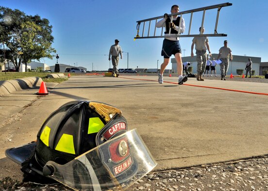 Lt. Col. Stamatis Smeltz, 96th Communication Squadron, carries a ladder in an early part of the first sergeants vs commanders’ challenge Oct. 7 at Eglin Air Force Base, Fla.  The challenge represented the physical training course new Airmen must accomplish to become Air Force firefighters.  The course included hose carrying, dragging and pulling, victim carry and climbing 10 steps up a ladder five times and more.   The shirts beat the commanders for a second year by a full minute with a combined time of 18 minutes, 11 seconds.   (U.S. Air Force photo/Samuel King Jr.)