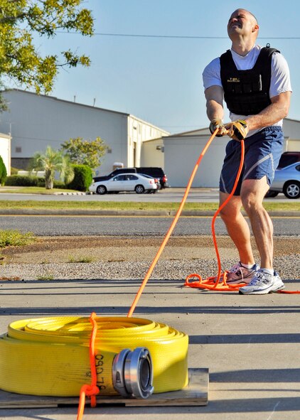 Master Sgt. Mike Hager, 33rd Maintenance Squadron, strains to pull the hose back to the line during the First Sergeants vs commanders’ challenge Oct. 7 at Eglin Air Force Base, Fla.  The challenge represented the physical training course new Airmen must accomplish to become Air Force firefighters.  The course included hose carrying, dragging and pulling, victim carry and climbing 10 steps up a ladder five times and more.  Sergeant Hager was the first on the course and had the best time among the shirts with four minutes 23 seconds.  The shirts beat the commanders for a second year by a full minute with a combined time of 18 minutes, 11 seconds.   (U.S. Air Force photo/Samuel King Jr.)