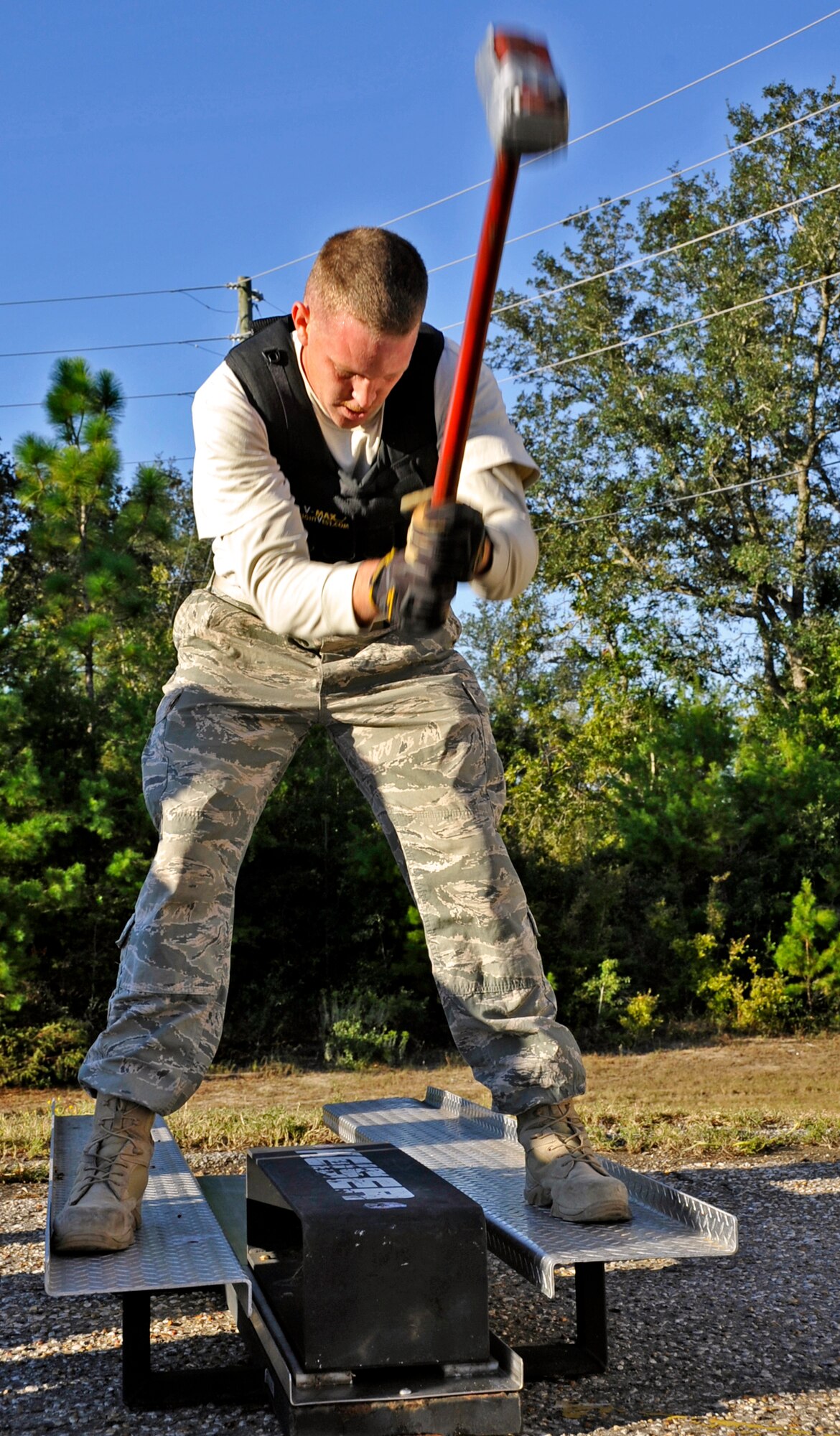 Staff Sgt. Tim Llewellyn, 96th Civil Engineer Squadron firefighter, brings the hammer down while demonstrating one of the challenges during the during the first sergeants vs commanders’ challenge Oct. 7 at Eglin Air Force Base, Fla.  The challenge represented the physical training course new Airmen must accomplish to become Air Force firefighters.  The course included hose carrying, dragging and pulling, victim carry and climbing 10 steps up a ladder five times and more.   The shirts beat the commanders for a second year by a full minute with a combined time of 18 minutes, 11 seconds.   (U.S. Air Force photo/Samuel King Jr.)