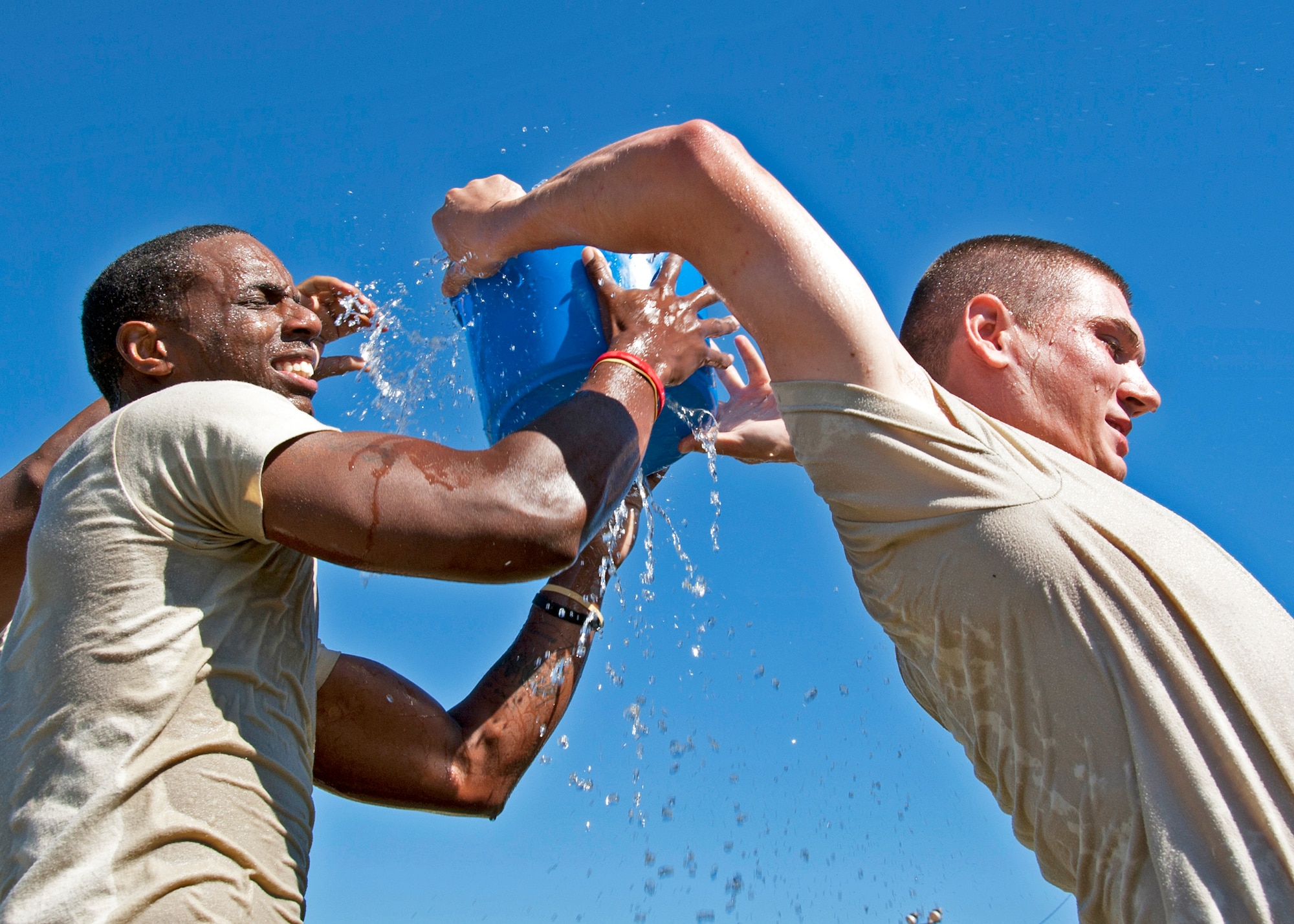 Senior Airman Bruce Bennett and Airman 1st Class William Parente, 96th Civil Engineer Group, pass buckets of water over their heads during the Fire Muster Challenge Oct. 4 at Eglin Air Force Base, Fla.  Teams competed in the challenge that included a ladder and hose carry, fire engine pull, and water relay.  (U.S. Air Force photo/Samuel King Jr.)