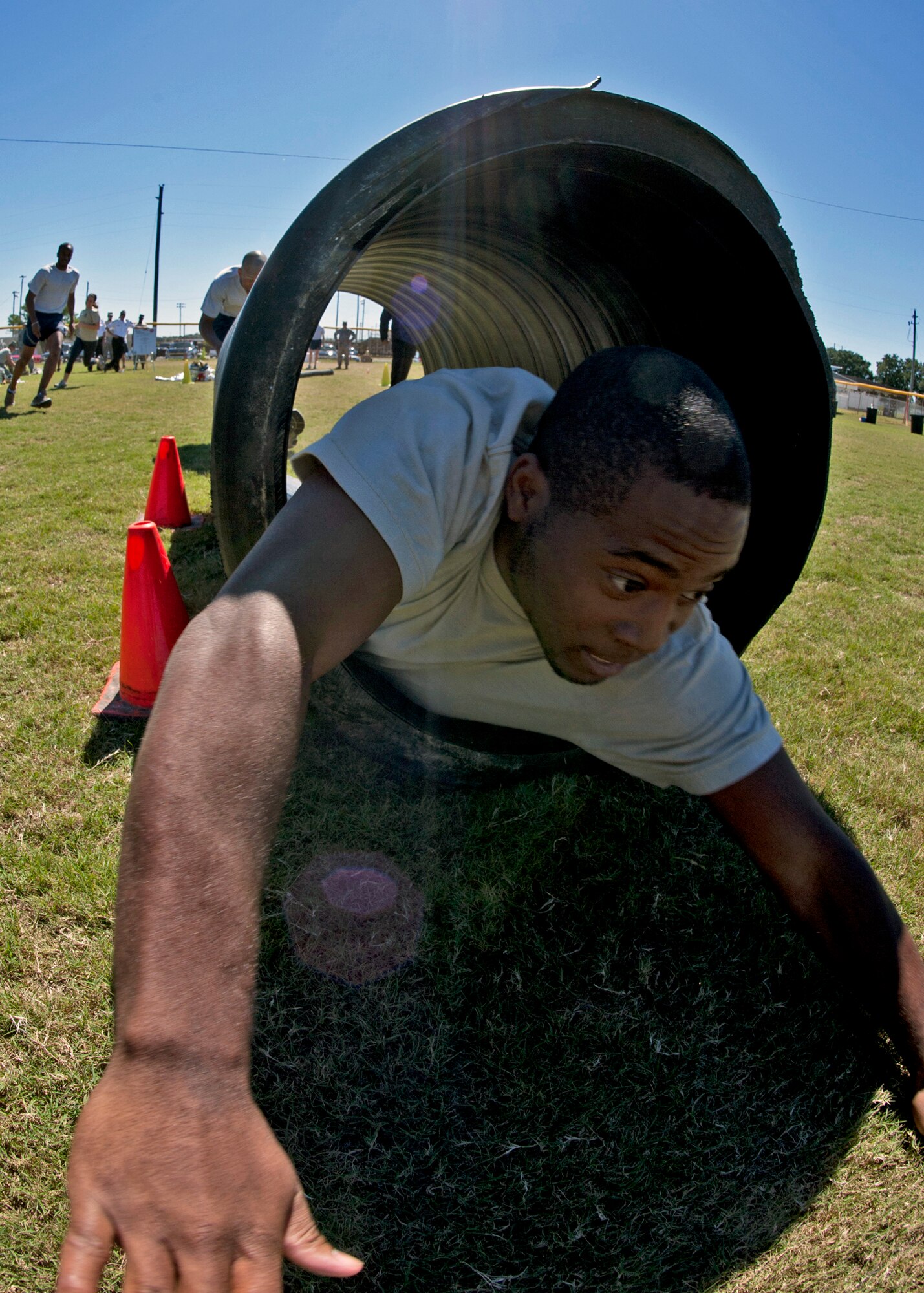 Senior Airman Cephas Stokling, 96th Comptroller Squadron, slides through a cylinder during the Fire Muster Challenge Oct. 4 at Eglin Air Force Base, Fla.  Teams competed in the challenge that included a ladder and hose carry, fire engine pull, and water relay.  (U.S. Air Force photo/Samuel King Jr.)