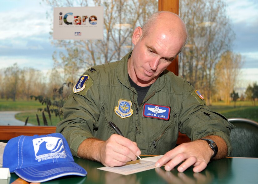 Col. John Quinn, 319th Air Refueling Wing vice commander signs his donation slip at the Combined Federal Campaign kick-off breakfast event Oct. 11 at Grand Forks Air Force Base, N.D. The CFC is the only authorized solicitation of federal employees in their workplaces on behalf of charitable organizations.  For more information on how to contribute, contact your unit CFC representative or visit http://www.cfctoday.org/_root/ (U.S. Air Force photo/Staff Sgt. Suellyn Nuckolls)