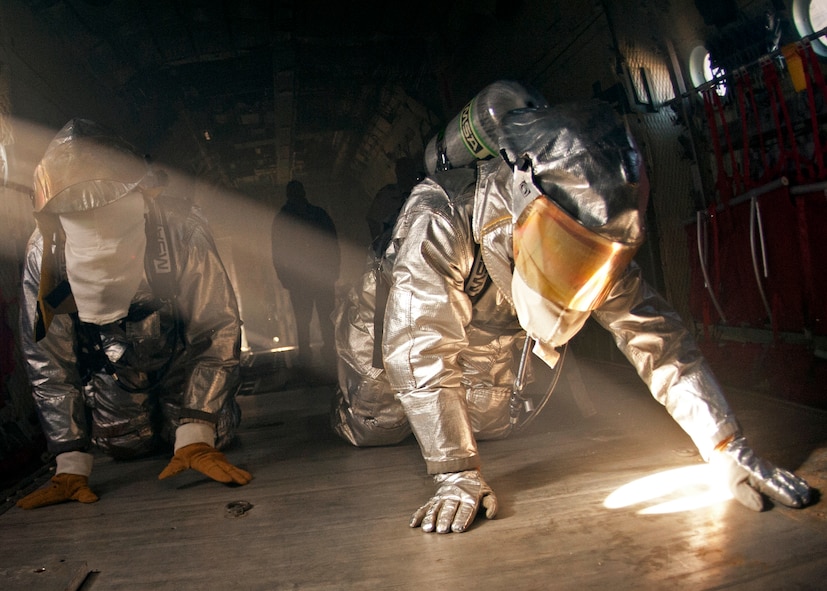 Team members feel their way through the C-130 looking for the victim while blindfolded during the commanders’ challenge event Oct. 4 at Eglin Air Force Base, Fla.  Base leaders and a partner had to enter the aircraft and find a simulated victim while blindfolded and in fire gear.  The exercise was to demonstrate first-hand what Air Force firefighters experience in the event of a fire.  (U.S. Air Force photo/Samuel King Jr.)