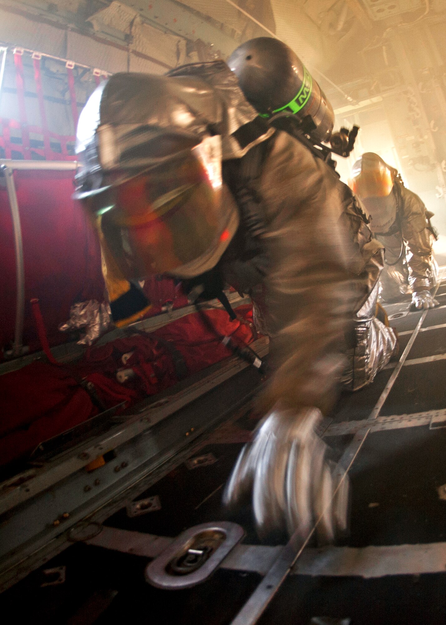 Team members feel their way through the C-130 looking for the victim while blindfolded during the commanders’ challenge event Oct. 4 at Eglin Air Force Base, Fla.  Base leaders and a partner had to enter the aircraft and find a simulated victim while blindfolded and in fire gear.  The exercise was to demonstrate first-hand what Air Force firefighters experience in the event of a fire.  (U.S. Air Force photo/Samuel King Jr.)