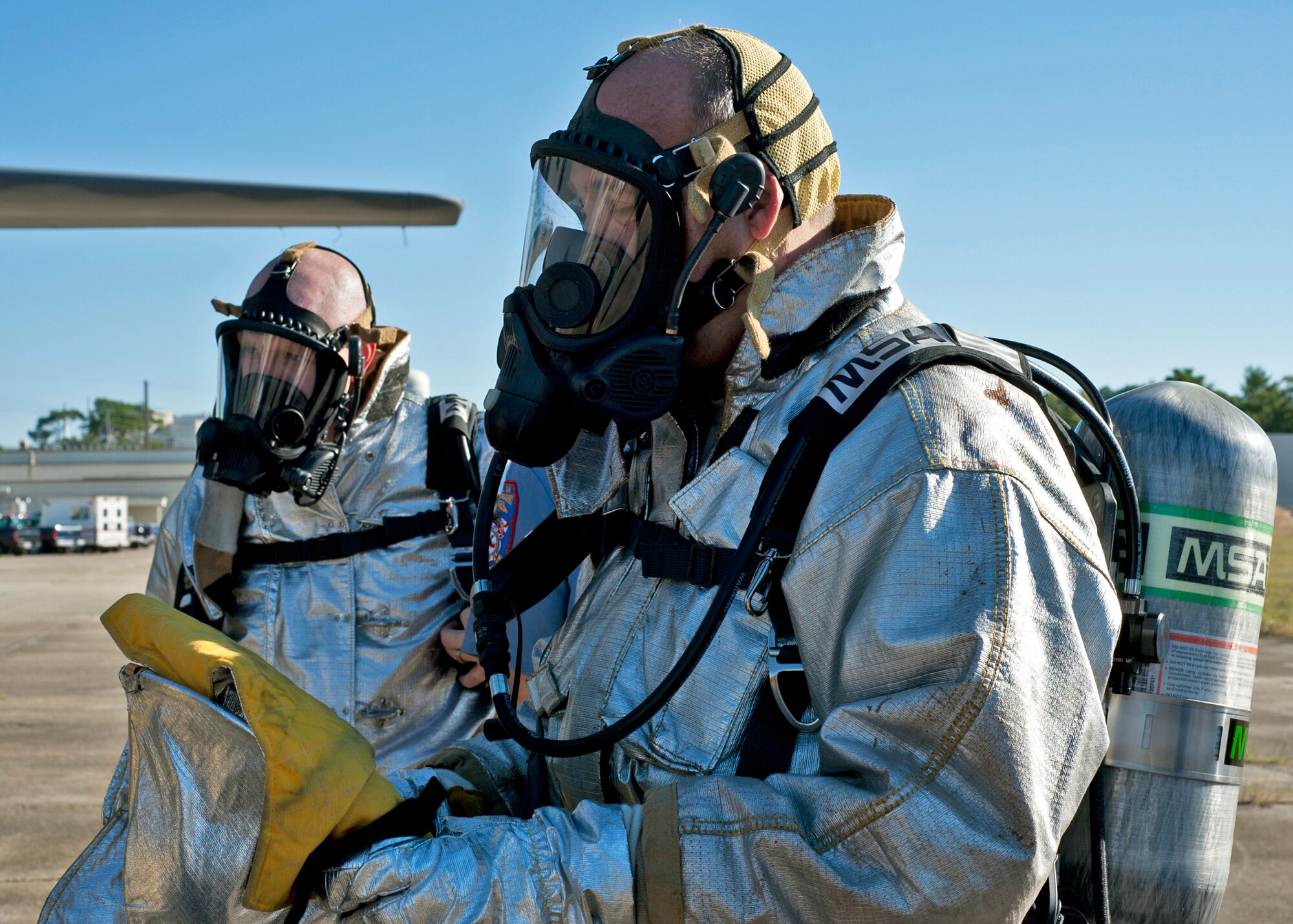 Col. Michael Brewer, 46th Test Wing commander (foreground) and his executive officer, Capt. Nicholas Coleman, prepare to enter the C-130 for the commanders’ challenge event Oct. 4 at Eglin Air Force Base, Fla.  Base leaders and a partner had to enter the aircraft and find a simulated victim while blindfolded and in fire gear.  The exercise was to demonstrate first-hand what Air Force firefighters experience in the event of a fire.  (U.S. Air Force photo/Samuel King Jr.)