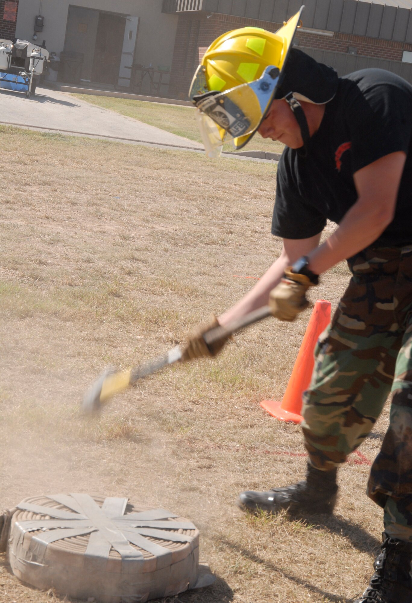 GOODFELLOW AIR FORCE BASE, Texas - Airman 1st Class Steve Scott, a 316th Training Squadron student swings a sledge hammer in an effort to drive a rolled up hose across a designated space during the Firefighter Muster, Oct. 8 at the Fire Station. The annual competition featured strength and speed testing challenges including the dummy drag, ladder climb, bucket brigade and extinguisher carry. (U.S. Air Force photo/Airman 1st Class Anne Gathua)

