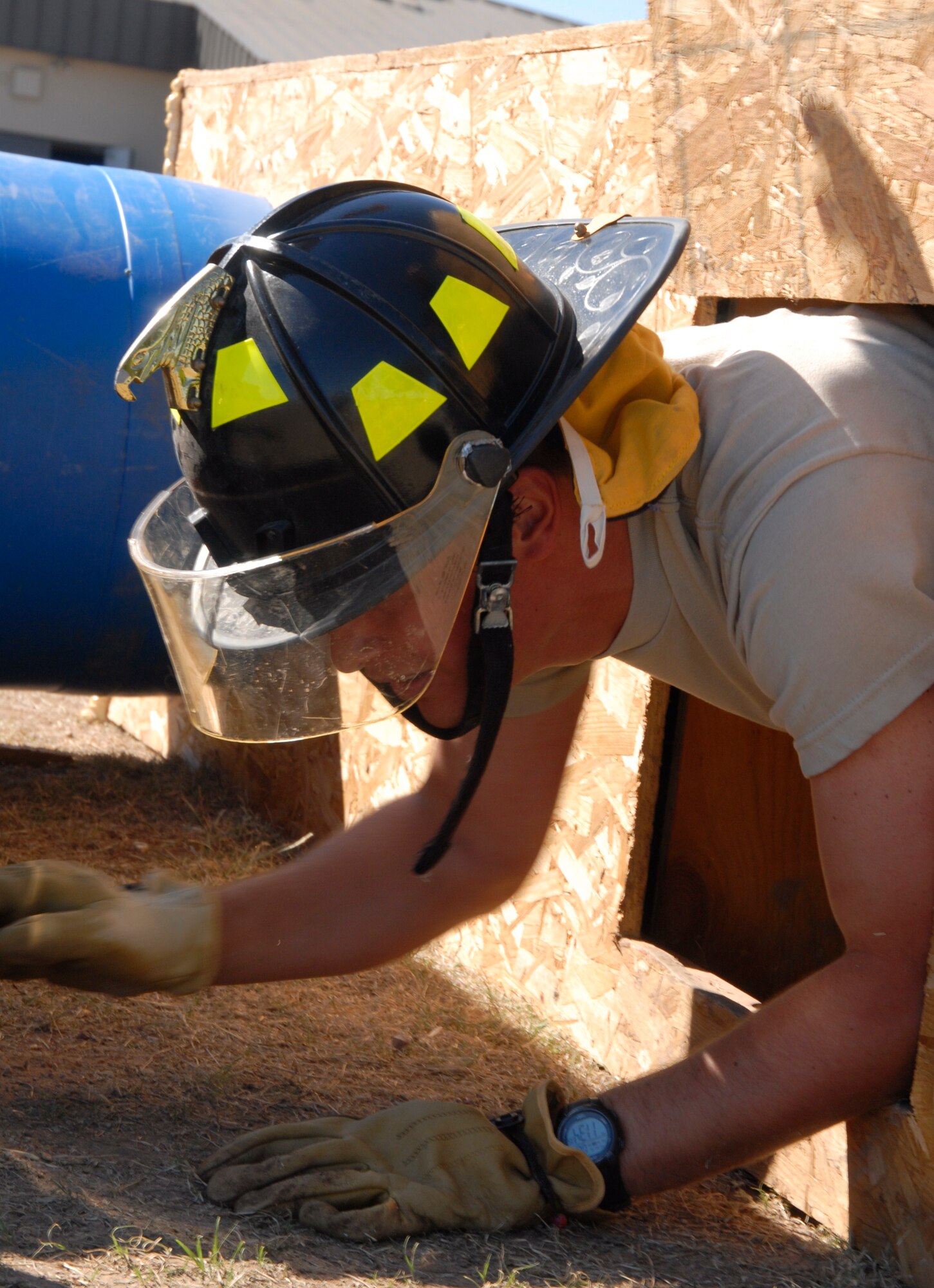 GOODFELLOW AIR FORCE BASE, Texas - Airman Basic Uvaldo Boix, a 316th Training Squadron student maneuvers his way through a makeshift tunnel during the confined space crawl at the Firefighter Muster held Oct. 8 at the Fire Station. The annual competition featured strength and speed testing challenges including the dummy drag, ladder climb, bucket brigade and extinguisher carry. (U.S. Air Force photo/Airman 1st Class Anne Gathua)