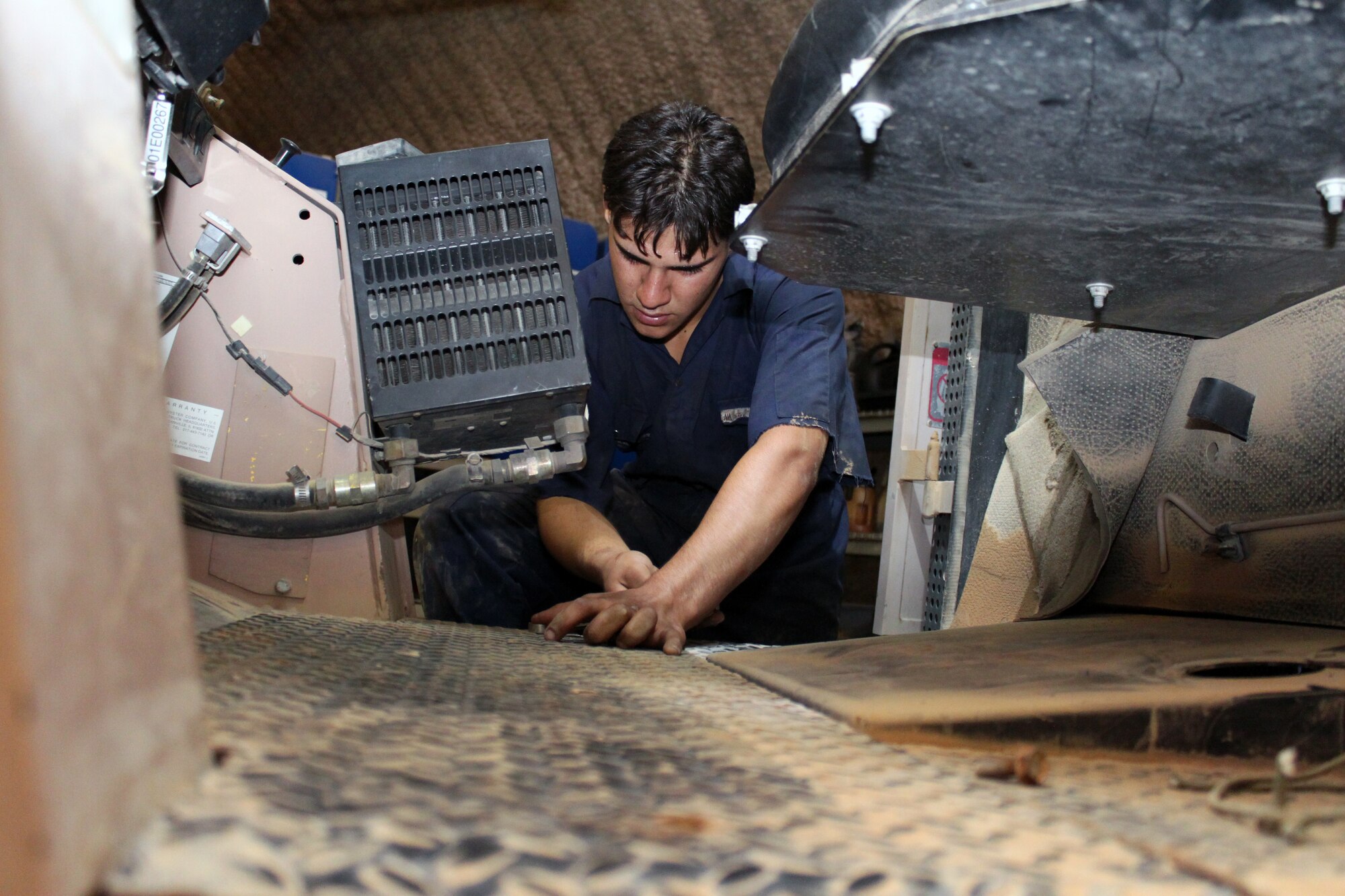 Hassan Al Hadi, an apprentice in the 332nd Expeditionary Logistics Readiness Squadron Vehicle Maintenance Flight Iraqi Mentorship Program, removes floor plate bolts on a forklift to gain access to parts below Aug. 11, 2010, Joint Base Balad, Iraq. Mr. Hadi is an apprentice in the 332 ELRS VMF IMP, which trains local men about general and specialized maintenance on vehicles so when they graduate they have a trade to support themselves and assist in building Iraq’s economy after the U.S. forces depart. (U.S. Air Force photo/Tech. Sgt. Stacy Fowler)