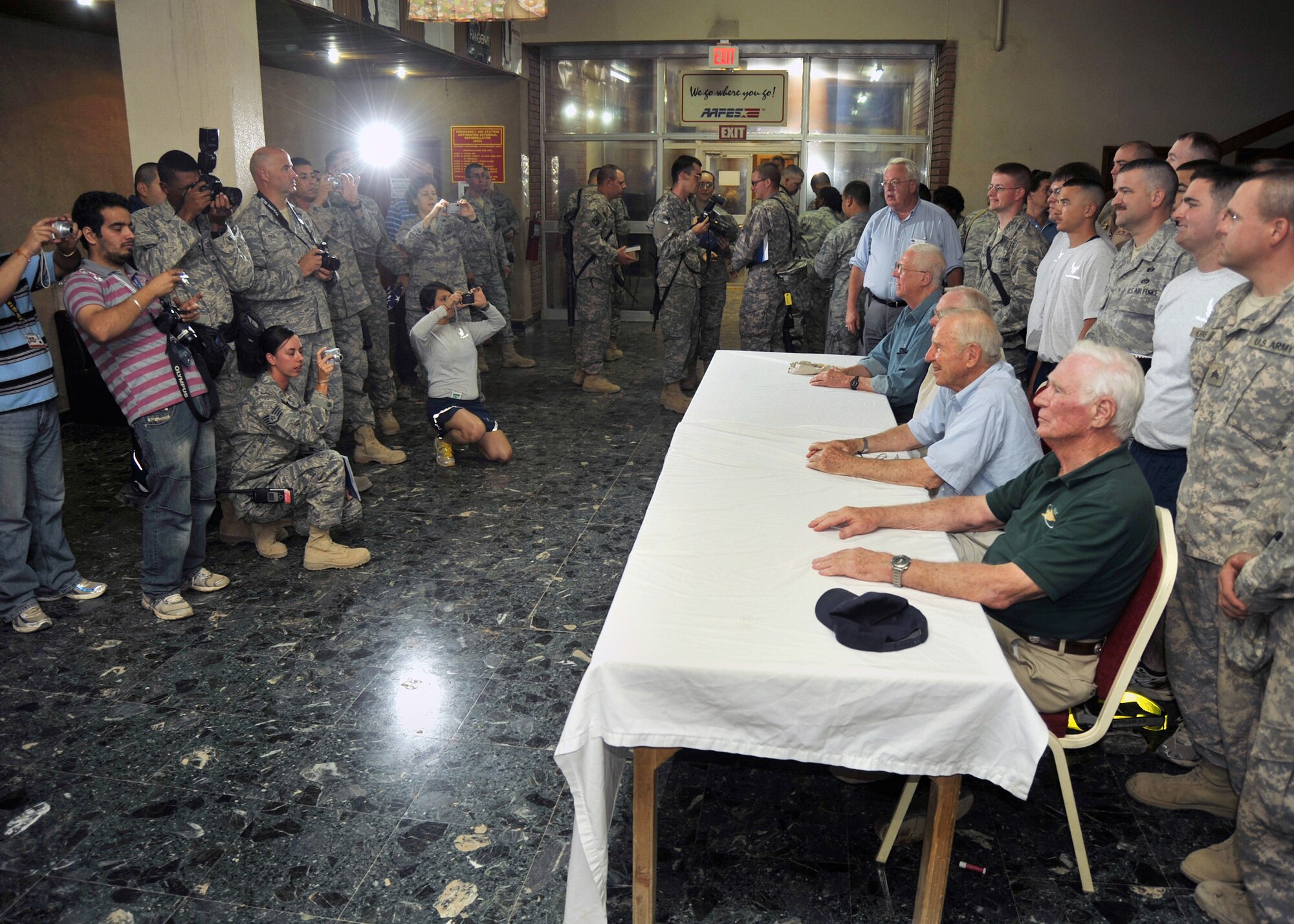 Astronauts Gene Cernan (front to back), Jim Lovell, Neil Armstrong and former "Good Morning America" host David Hartman pose for photos with service members in the lobby of the Sustainer Theater, Joint Base Balad, Iraqi, Oct. 11, 2010. During an earlier panel discussion, the spaceflight pioneers shared their groundbreaking aerospace experiences. As Apollo 11 commander, Neil Armstrong was the first human to walk on the moon; retired Navy Capt. Jim Lovell was the commander of the ill-fated Apollo 13 mission; retired Navy Capt. Gene Cernan, Apollo 17 commander, was the last human to depart from the moon. The visit was part of the "Legends of Aerospace Tour," sponsored by the USO and Armed Forces Entertainment, touring bases in Europe and Southwest Asia.  (U.S. Air Force photo/Lt. Col. Robert Couse-Baker)
