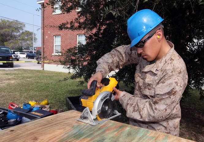 Lance Cpl. Robert Gomez Jr. a combat engineer with Alpha Company, 8th Engineer Support Battalion, 2nd Marine Logistics Group, cuts a piece of wood that will later be used to assemble the Combat Operation Center Oct. 13, 2010, aboard Camp Lejeune, N.C.  Marines are working to complete the first of stage of what will be an exact replica of the COC operating in Afghanistan. (U.S. Marine Corps photo by Lance Cpl. Bruno J. Bego)