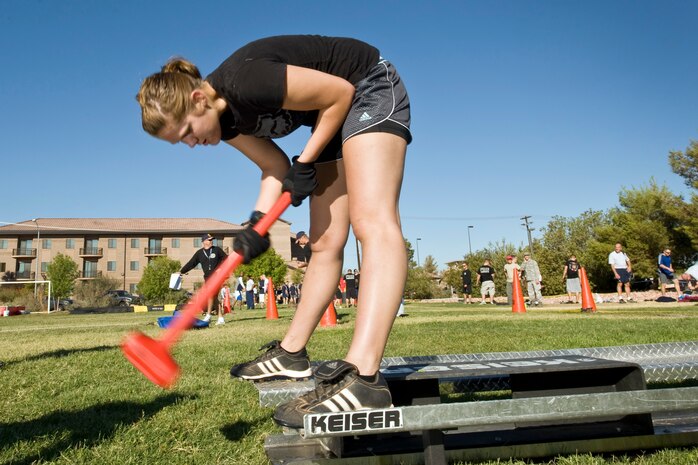 NELLIS AIR FORCE BASE, Nev.-- Airman 1st Class Kari Randall, 6th Combat Training Squadron swings a sledge hammer on the Keiser sled portion of the confidence course during the 4th annual Fire Muster competition at the Nellis Sport Pavilion Oct. 8. The Fire Muster was sponsored by the Nellis Fire Department.  (U.S. Air Force photo by Lawrence Crespo)

 
