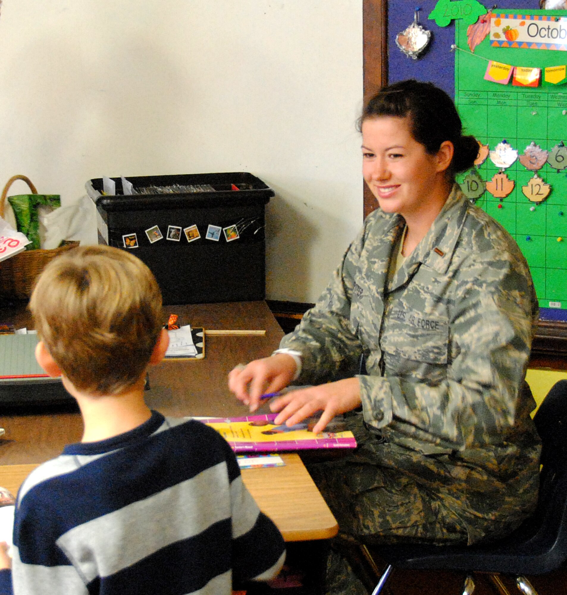 2nd Lt. Laura Dempster helps a student with his reading skills while working as a volunteer at Taft elementary school. (U.S. Air Force Photo)