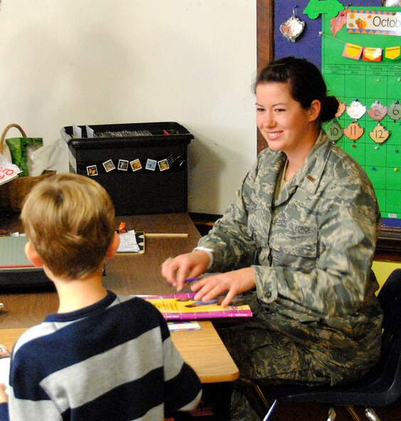 2nd Lt. Laura Dempster helps a student with his reading skills while working as a volunteer at Taft elementary school. (U.S. Air Force Photo)