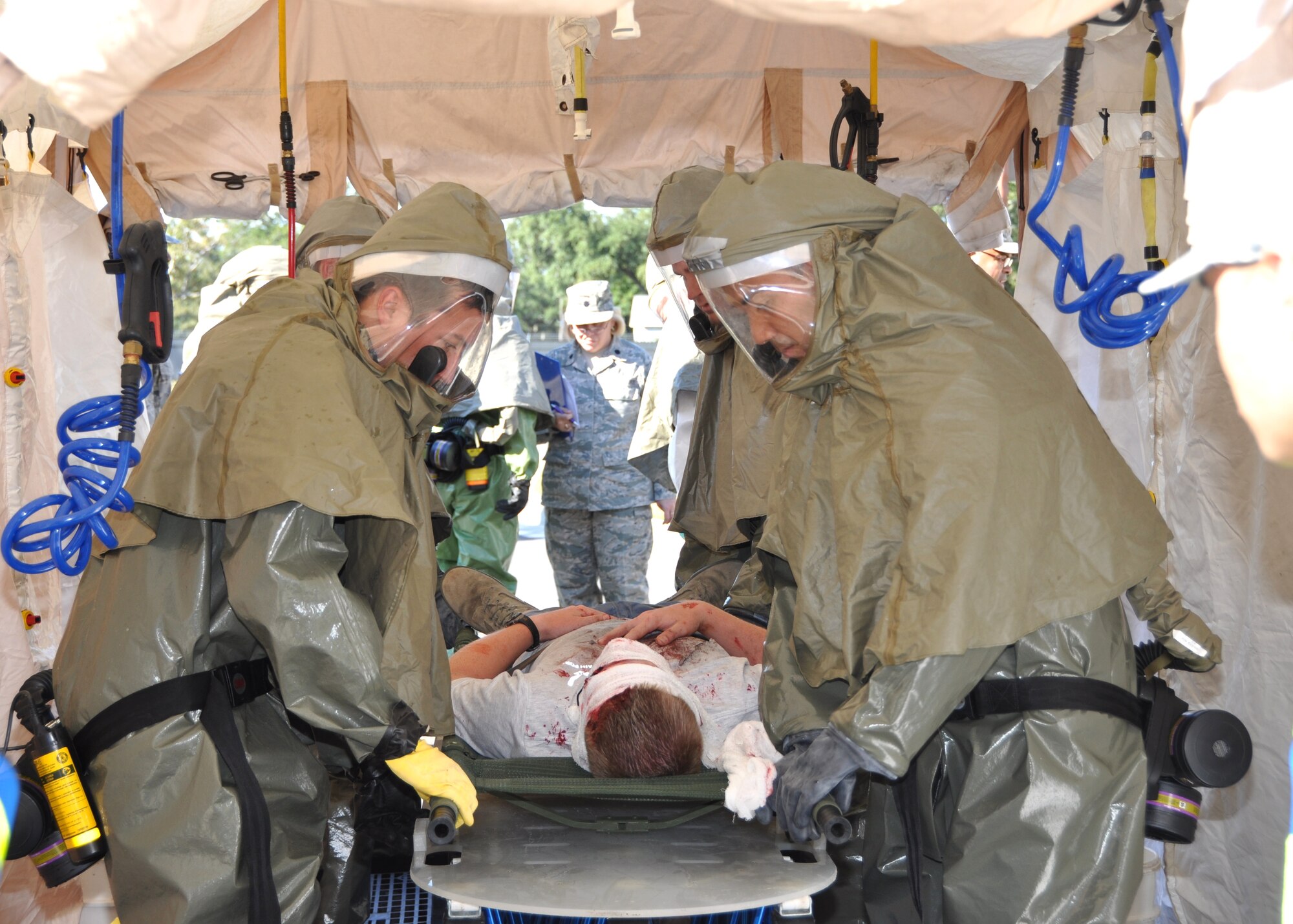 The in-place patient decontamination team cleans an accident victim before he can be seen by medical providers outside the hospital‘ s emergency department.  (U.S. Air Force photo by Steve Pivnick)