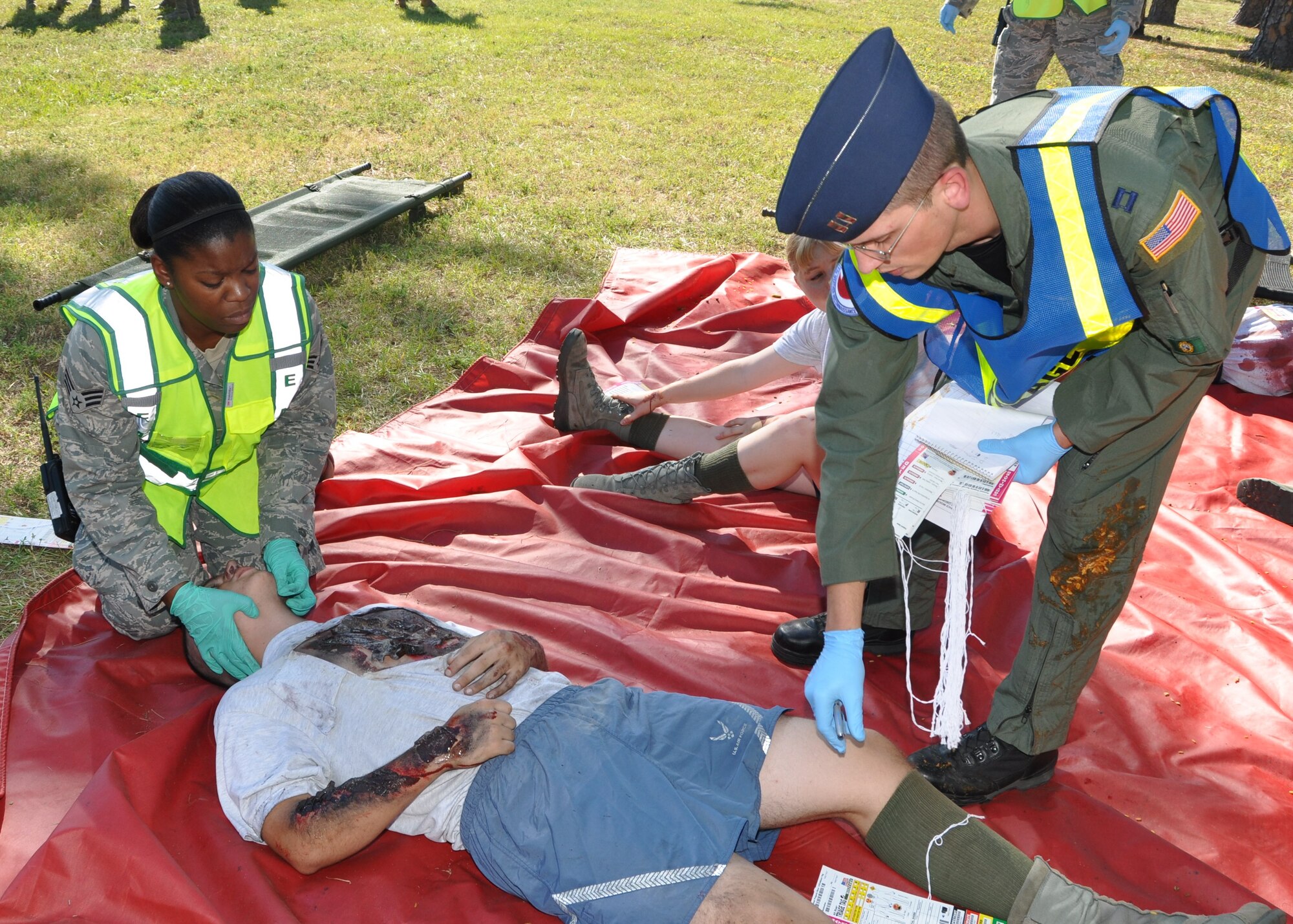 Senior Airman Kendra Henderson, 81st MDOS, assists Capt. (Dr.) Robert Henley, 81st Aerospace Medicine Squadron, as he evaluates accident victimAirman Basic Justin Brueckner, 332nd TRS.  (U.S. Air Force photo by Steve Pivnick)