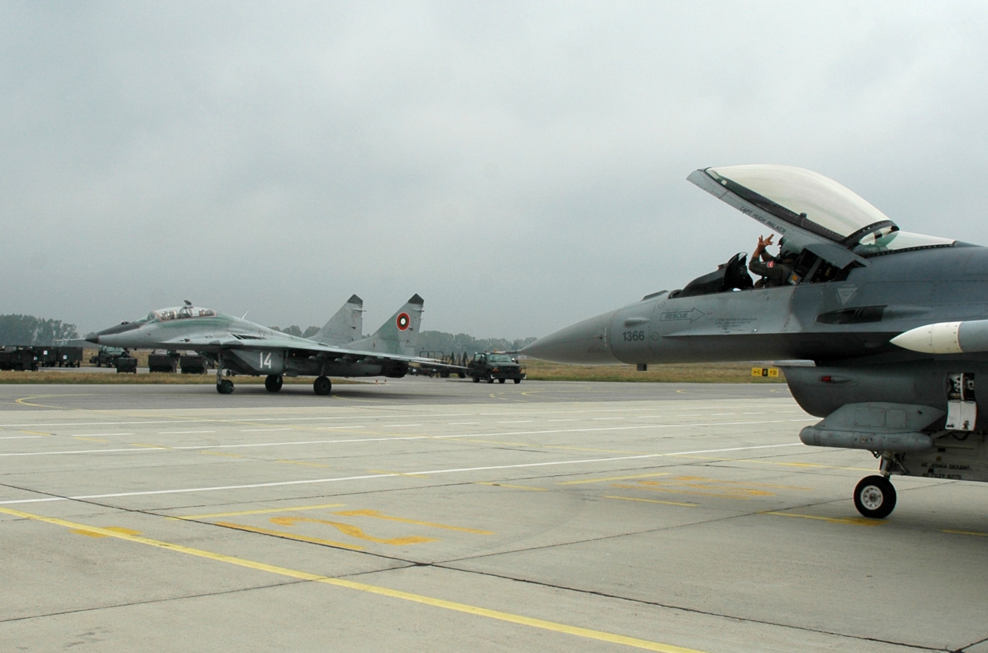 GRAF IGNATIEVO AIR FORCE BASE, Bulgaria -- An F-16 Fighting Falcon pilot from Spangdahlem Air Base's 480th Fighter Squadron gives a "Warhawk wave" to a taxiing MiG 29 during Operation Thracian Star Oct. 13. During the operation F-16 pilots from the 480th FS trained against MiG 29 and MiG 21 aircraft as well as practiced suppression and destruction of enemy air defense systems. (U.S. Air Force photo/Maj. Jillian Torango)