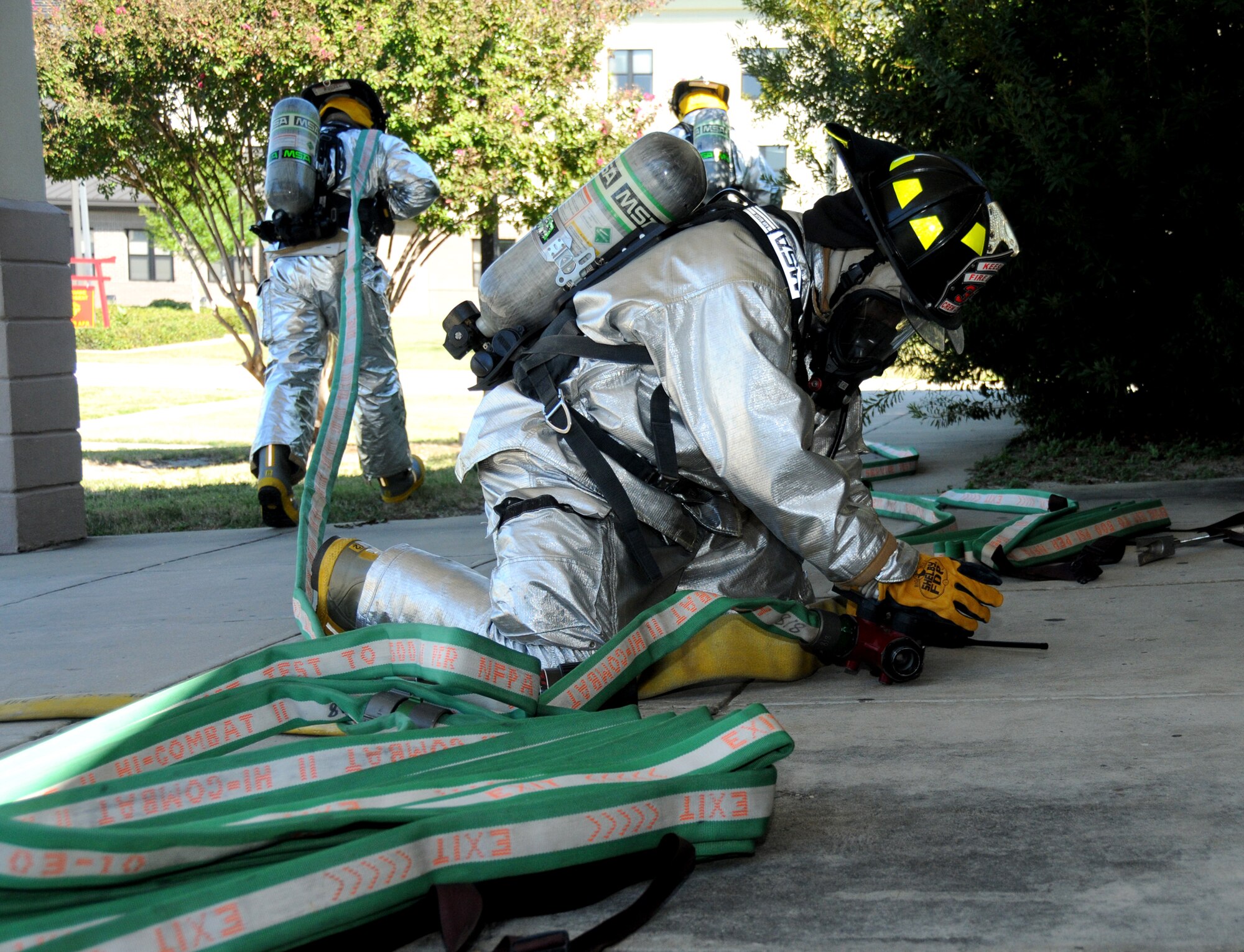 Staff Sgt. DonaldWalker, left, andAirman 1st Class Jeffrey Spivey connect hoses before enteringWelch Auditorium.   (U.S. Air Force photo by Kemberly Groue)