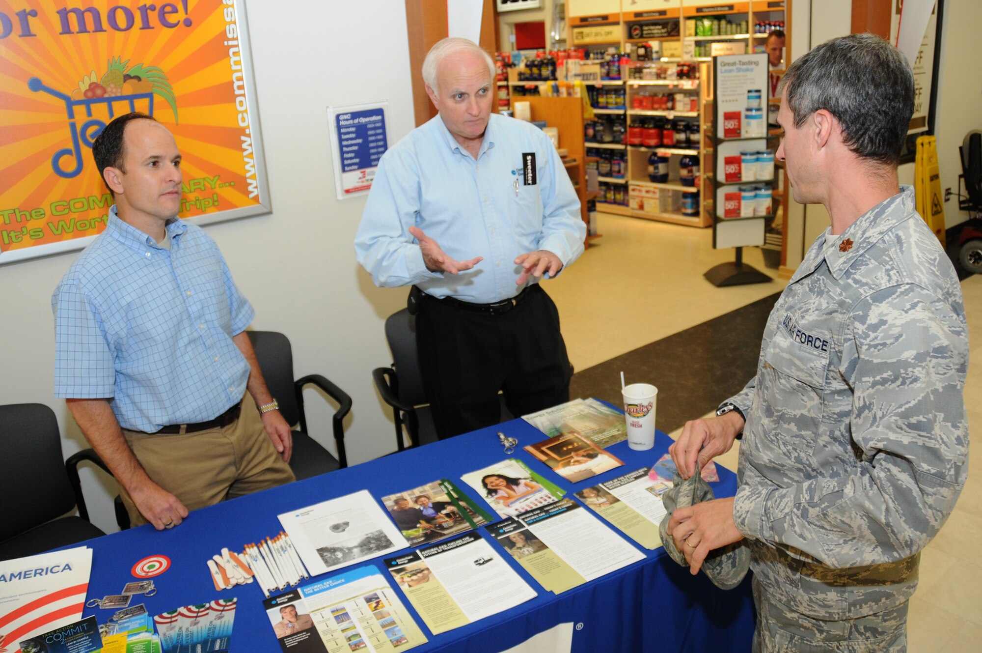 Adrian Barcomb, left, base resource efficiency manager from CSC, and Charles Campbell from Center Point Energy, Keesler’s natural gas provider, provide information on energy awareness to Maj. Matthew Atkinson, 81st Logistics Readiness Squadron, Oct. 5 at the exchange/commissary complex. Other energy providers will be featured at similar booths throughout the month.  (U.S. Air Force photo by Kemberly Groue)