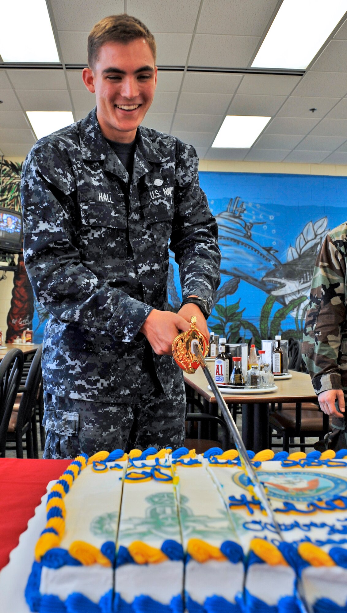 Seaman Kyle Hall, 19-year-old student at the Navy Explosive Ordnance Disposal School slices up the cake celebrating the 235 birthday of the U.S. Navy Oct. 13.  (U.S. Air Force photo/Samuel King Jr.)