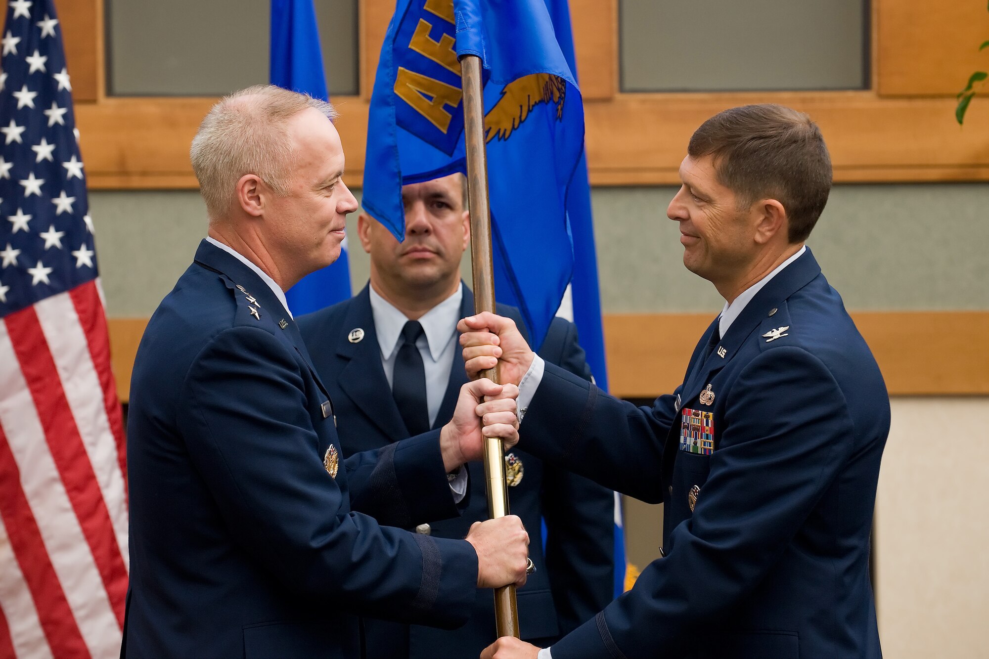 Col. Thomas C. Joyce accepts the Air Force Mortuary Affairs Operations Center guidon from Lt. Gen. Richard Y. Newton III, Deputy Chief of Staff for Manpower and Personnel, Headquarters U.S. Air Force, Washington, D.C., during a Change of Command ceremony Oct. 7. (U.S. Air Force photo/Roland Balik)