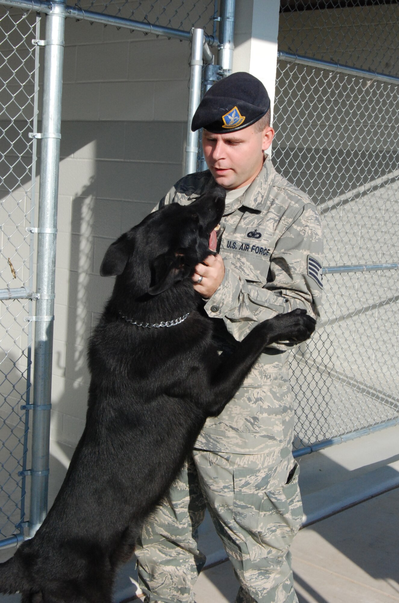 Staff Sgt. Lewis C. Collins, a dog handler at the 82nd Security Forces Squadron, pets Larry, a military working dog at Sheppard Air Force Base, Texas. Larry and Sheppard's other MWDs received a new home recently when construction was completed on new dog kennels. (U.S. Air Force photo/Mike McKito)