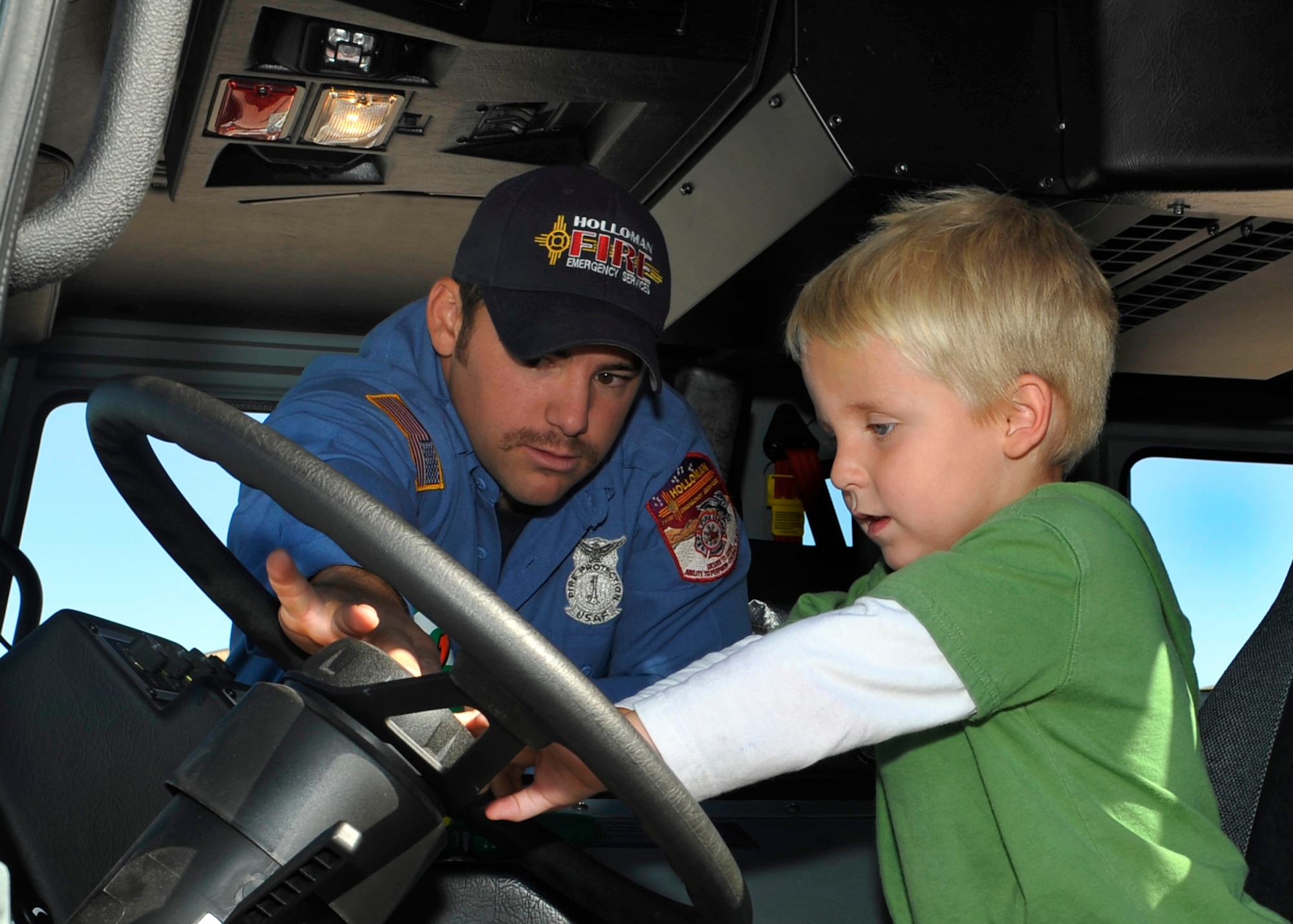 HOLLOMAN AIR FORCE BASE, N.M. -- Marcus Carpenter, an engineer with the 49th Civil Engineer Squadron's Fire Department, shows Bradley Eichmeier, son of Staff Sgt. Chad Eichmeier, 8th Aircraft Maintenance Unit, how to honk the horn of a fire truck after a fire drill during Fire Prevention Week Oct. 7, 2010. Children from the Child Development Center had the opportunity to meet Sparky the Fire Dog and climb inside a fire truck to see what its like to be in the shoes of a firefighter. (U.S. Air Force photo by Senior Airman Veronica Stamps / Released)