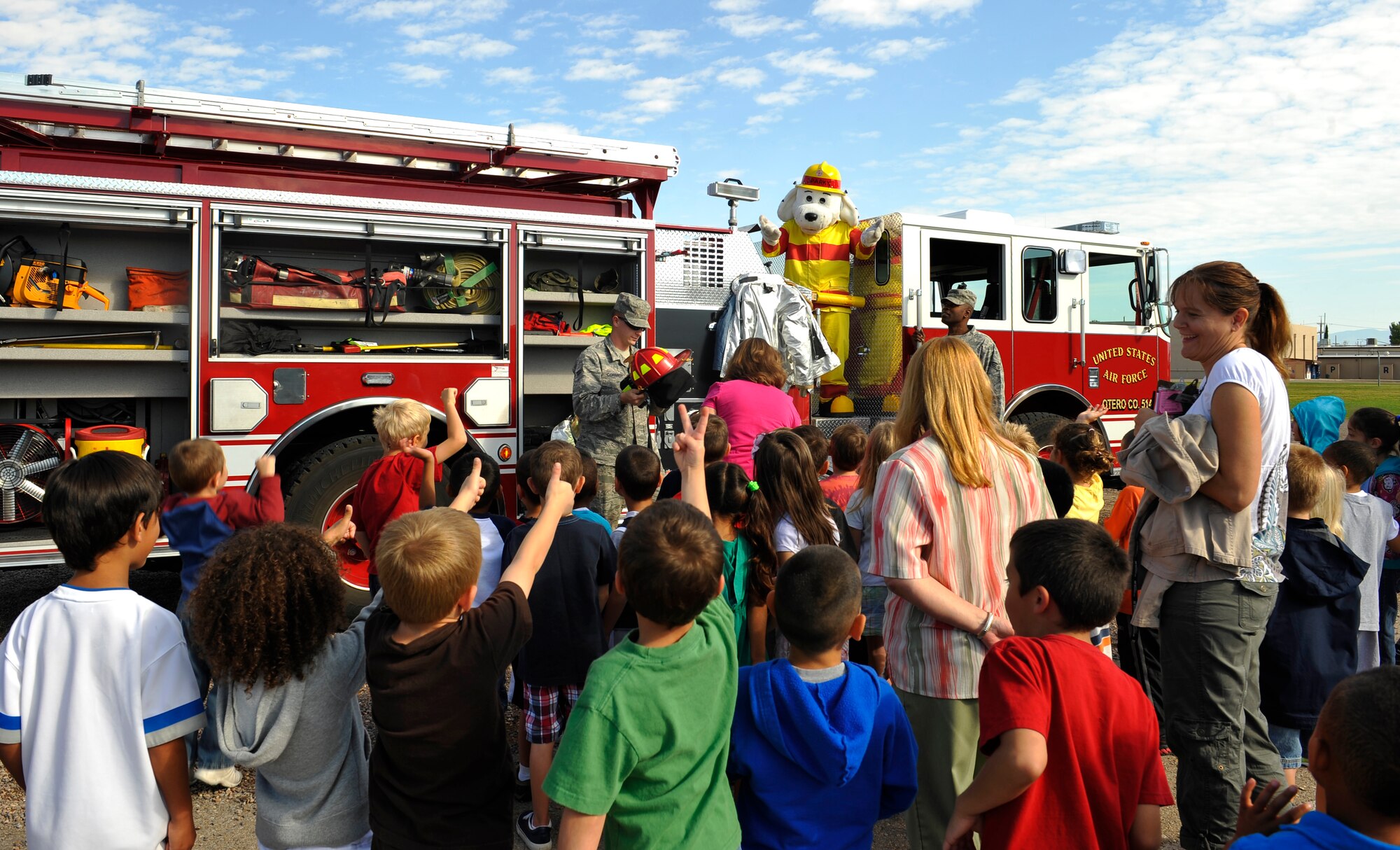 HOLLOMAN AIR FORCE BASE, N.M. -- Sparky the Fire Dog and 49th Civil Engineer Squadron firefighters meet with students at Holloman Elementary School after a fire drill Oct. 6, 2010. Students took a closer look at a fire truck and had the chance to try on a fire hat as part of Fire Prevention Week. Members of the 49th CES Fire Department conducted fire equipment demonstrations and performed fire evacuation drills throughout the week to promote fire safety awareness.  (U.S. Air Force photo by Senior Airman Veronica Stamps / Released)