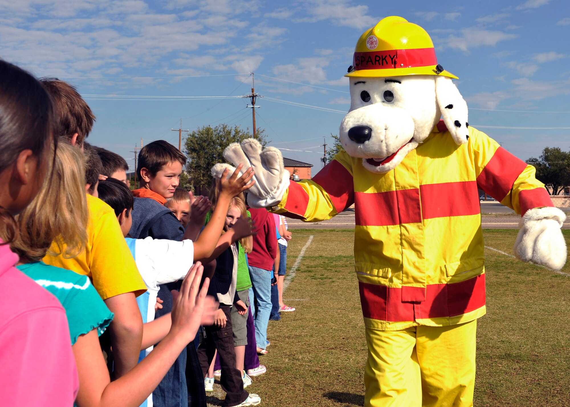 HOLLOMAN AIR FORCE BASE, N.M. -- Sparky the Fire Dog high-fives students from Holloman Elementary School after completing a fire drill during Fire Prevention Week Oct. 6, 2010. The 49th Civil Engineer Squadron Fire Department conducts a fire drill once a month at Holloman Elementary and Middle schools, Child Development Center and the Youth and Teen Center to practice fire evacuation points and reporting procedures. (U.S. Air Force photo by Senior Airman Veronica Stamps / Released)