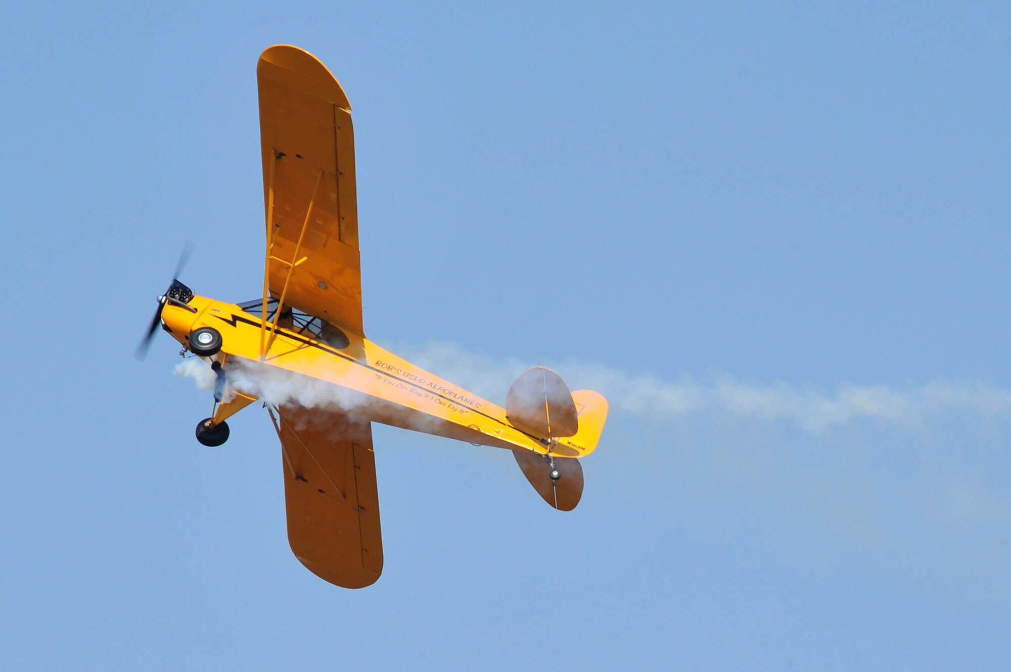 Greg Koontz, playing a farmer named Clem Cleaver, flies a 1946 Piper J-3 Cub Oct. 10 during a comedy routine at the Thunder Over the Rock air show. The comedy routine is about an Alabama redneck, Clem Cleaver, who steals the aircraft and lands on a moving pickup truck. (U.S. Air Force photo by Staff Sgt. Chris Willis)