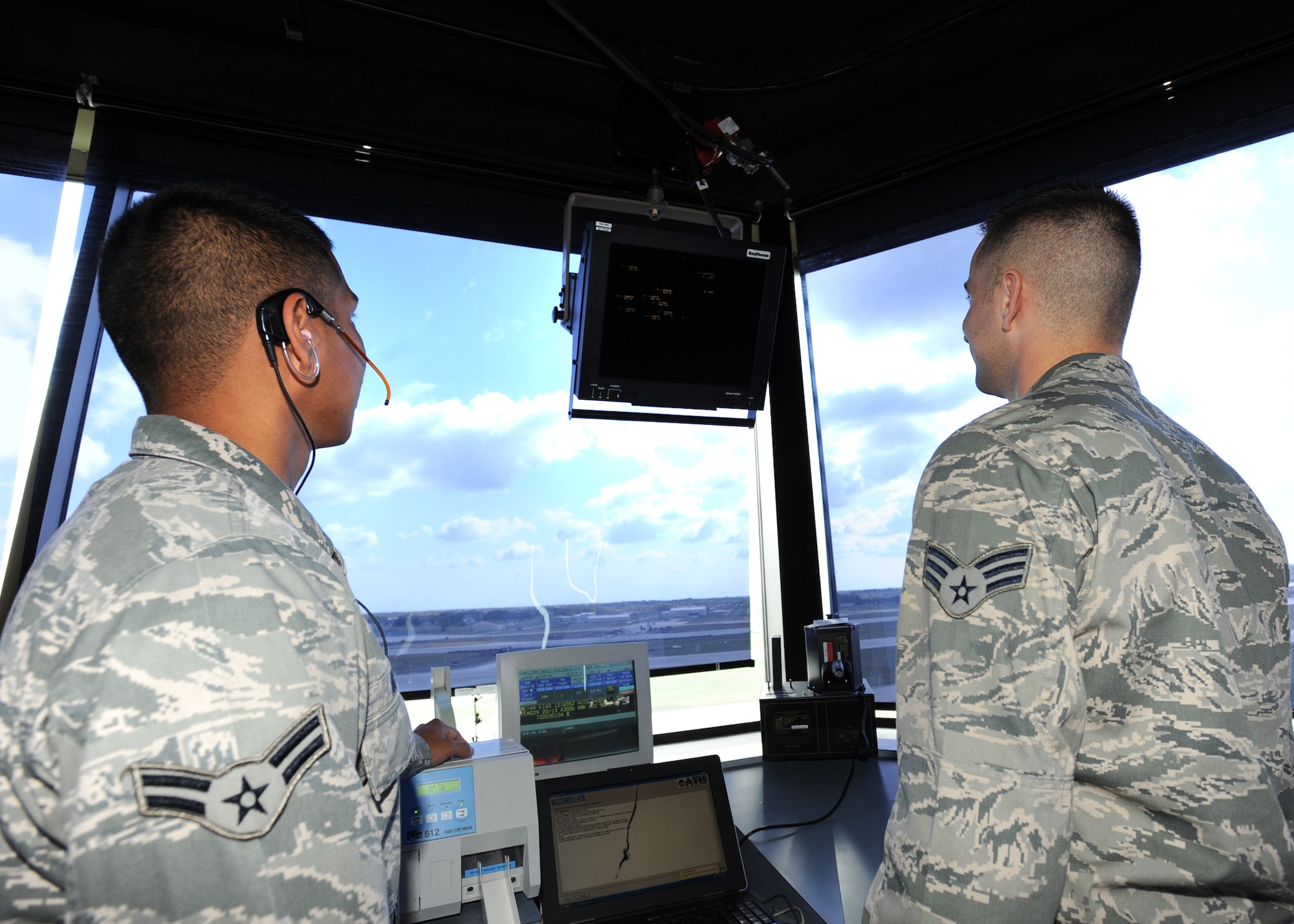 (Left) Airman 1st Class Kevin Notah and Senior Airman Aaron Lynde, 22nd Operation Support Squadron air traffic controllers, use radar to view the locations of aircraft within a 64-mile radius of the base, Oct. 12, 2010, McConnell Air Force Base, Kan.   This radar system helps controllers determine what aircraft are flying in the air space. ATCs are responsible for plotting aircraft positions with radar equipment, as well as computing aircraft speed, direction and altitude.  (U.S. Air Force photo/Airman 1st Class Andrea Salazar)