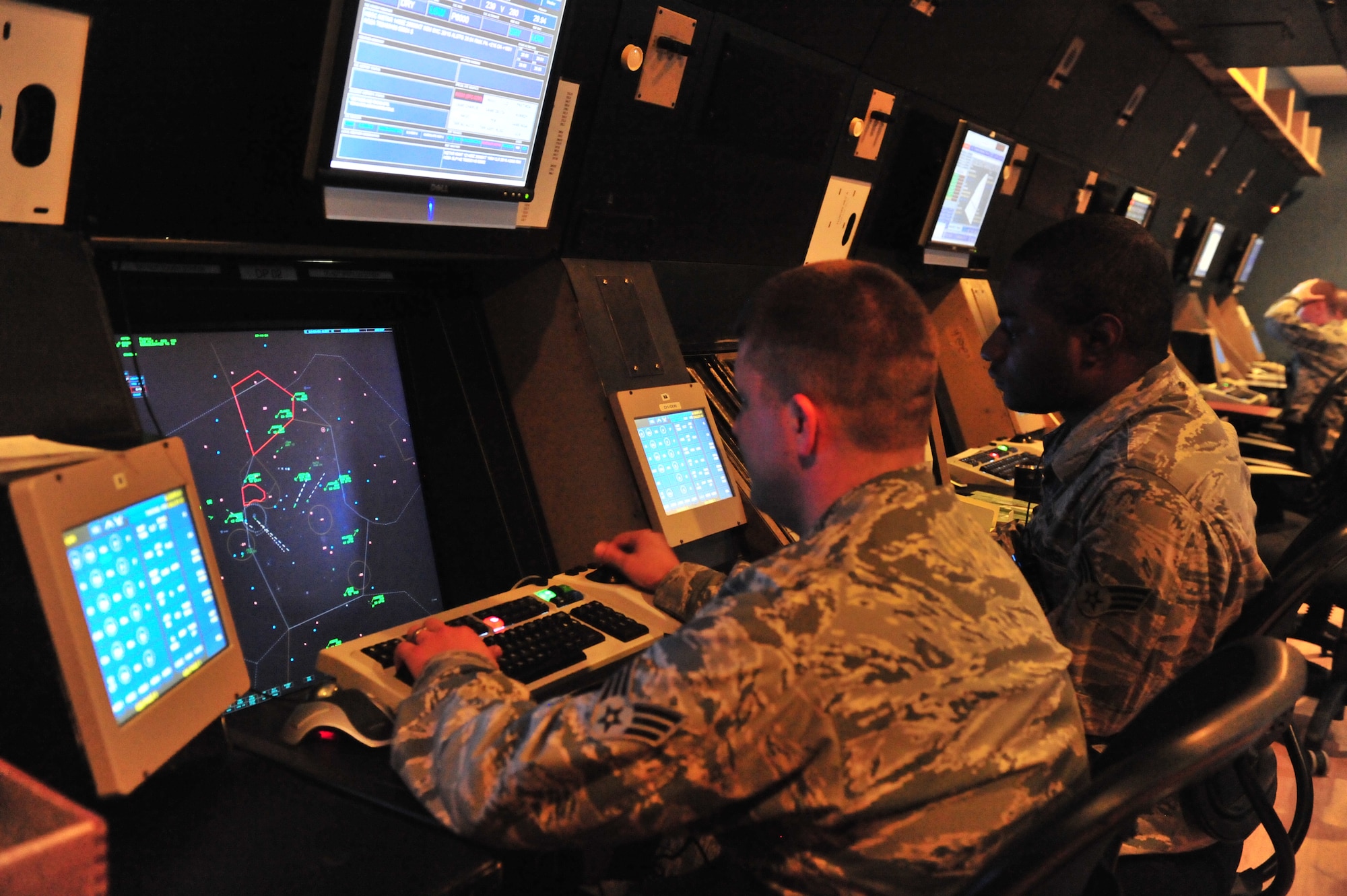 101012-F-8430J-013
SHAW AIR FORCE BASE, S.C. - Senior Airman Kenneth Small (right) assists Senior Airman Matthew De Young (left), 20th Operational Support Squadron radar approach control air traffic controller, during a training simulation at the RAPCON Squadron on Oct. 12, 2010. The air traffic controller career field is broken down into two parts: tower and radar, both work together to ensure that aircraft launch, fly and arrive safely. RAPCON's main mission is to work with larger distances and the planes that cannot be visually seen. Air traffic controllers go through extensive training since there is a 50 to 60 percent washout rate after technical school. (U.S. Air Force photo/Airman 1st Class Amber E. N. Jacobs (Released))