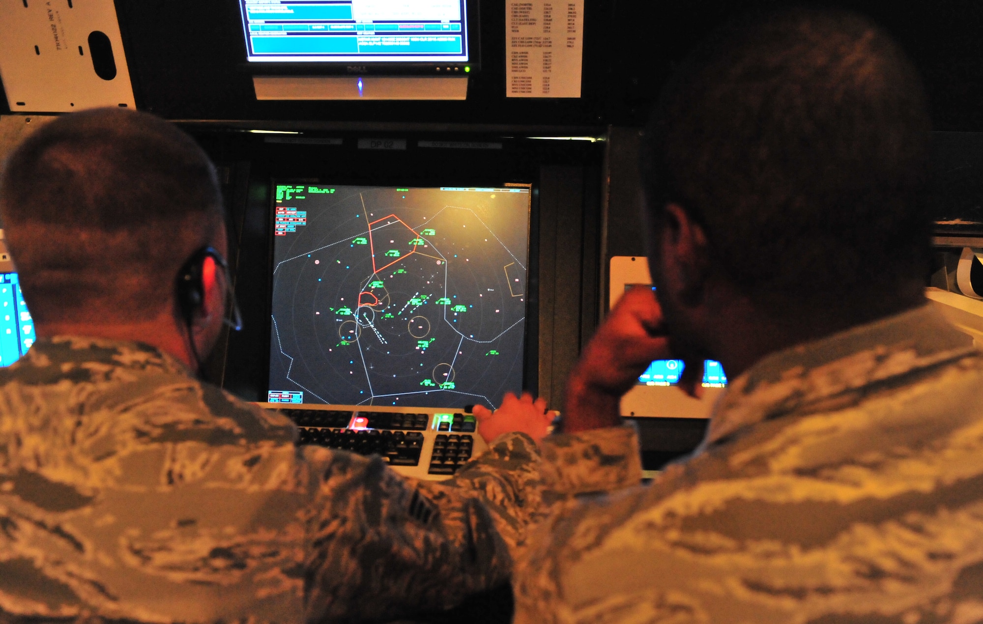 101012-F-8430J-007
SHAW AIR FORCE BASE, S.C. - Senior Airman Kenneth Small (right) assists Senior Airman Matthew De Young (left), 20th Operational Support Squadron radar approach control air traffic controller, during a training simulation at RAPCON on Oct. 12, 2010. The air traffic controller career field is broken down into two parts: tower and radar, both work together to ensure that aircraft launch, fly and arrive safely. RAPCON's main mission is to work with larger distances and the planes that cannot be visually seen. Air traffic controllers go through extensive training since there is a 50 to 60 percent washout rate after technical school. (U.S. Air Force photo/Airman 1st Class Amber E. N. Jacobs (Released))