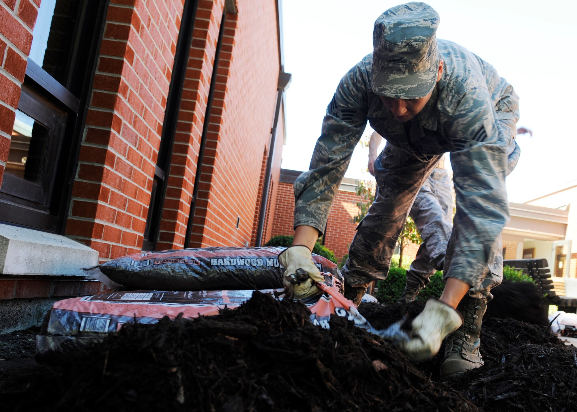 SCOTT AIR FORCE BASE, Ill. -- Senior Airman Anna Jones, 375th Air Mobility Wing Chapel, cuts open a bag of mulch as a part of Scott PRIDE Oct. 8 . Scott Pride is a way to remind base personnel to keep their buildings and surrounding areas looking sharp. Scott PRIDE is a 375th AMW led program that focuses on improving the already outstanding appearance of the base by fostering ownership through base-wide participation.  The program provides standards and guidelines for commanders, supervisors, and Team Scott servicemembers to achieve excellence in base appearance year-round. (U.S. Air Force photo/ Staff Sgt. Ryan Crane)