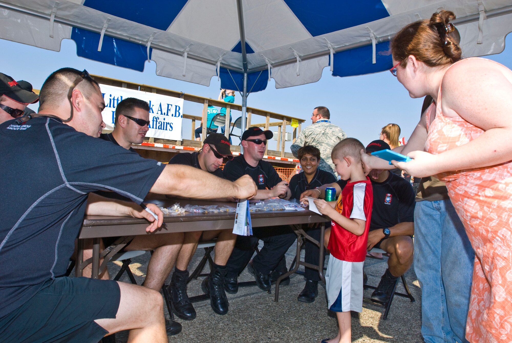 Members of the Canadian Forces Sky Hawks Parachute Team sign autographs for fans during the Thunder Over the Rock air show Oct. 10 at Little Rock Air Force Base, Ark. The team was one of 18 performers appearing each day at the two-day event. (U.S. Air Force photo by Staff Sgt. Nestor Cruz)