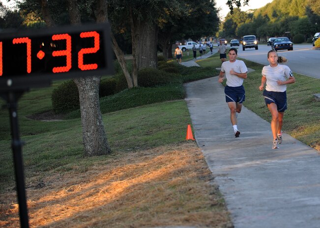 Closing in on the 18-minute mark, Airmen dash toward the finish line during the Commander's Fitness Challenge run Oct. 8, 2010, on Joint Base Charleston, S.C. The run kicked off with remarks from the Joint Base Charleston commander and Health and Wellness Center director, encouraging all of Team Charleston to continue engaging in physical activity during the holiday months and warned against over-indulgence. The HAWC offers several classes and services to aid members in achieving that goal and is located at the rear entrance of the Fitness and Sports Center on the Air Base. (U.S. Air Force photo/Senior Airman Timothy Taylor)