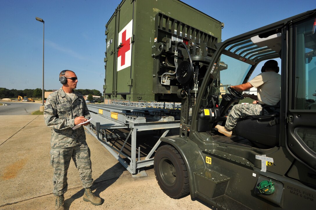 Staff Sgt. David A. Hagan II, 89th Aerial Port Squadron air transportation  standardization evaluator, monitors as Staff Sgt. Jonathan Gordner, 89 APS unit training manager, stages an ISU 90 mobile container full of medical supplies onto a pallet from a recent medical evacuation mission. Sergeant Hagan is responsible for ensuring evaluations are being accomplished to provide the unit commander, leadership, and Air Mobility Command with factual information about the health and effectiveness of the squadron. (U.S. Air Force photo/ Bobby Jones)