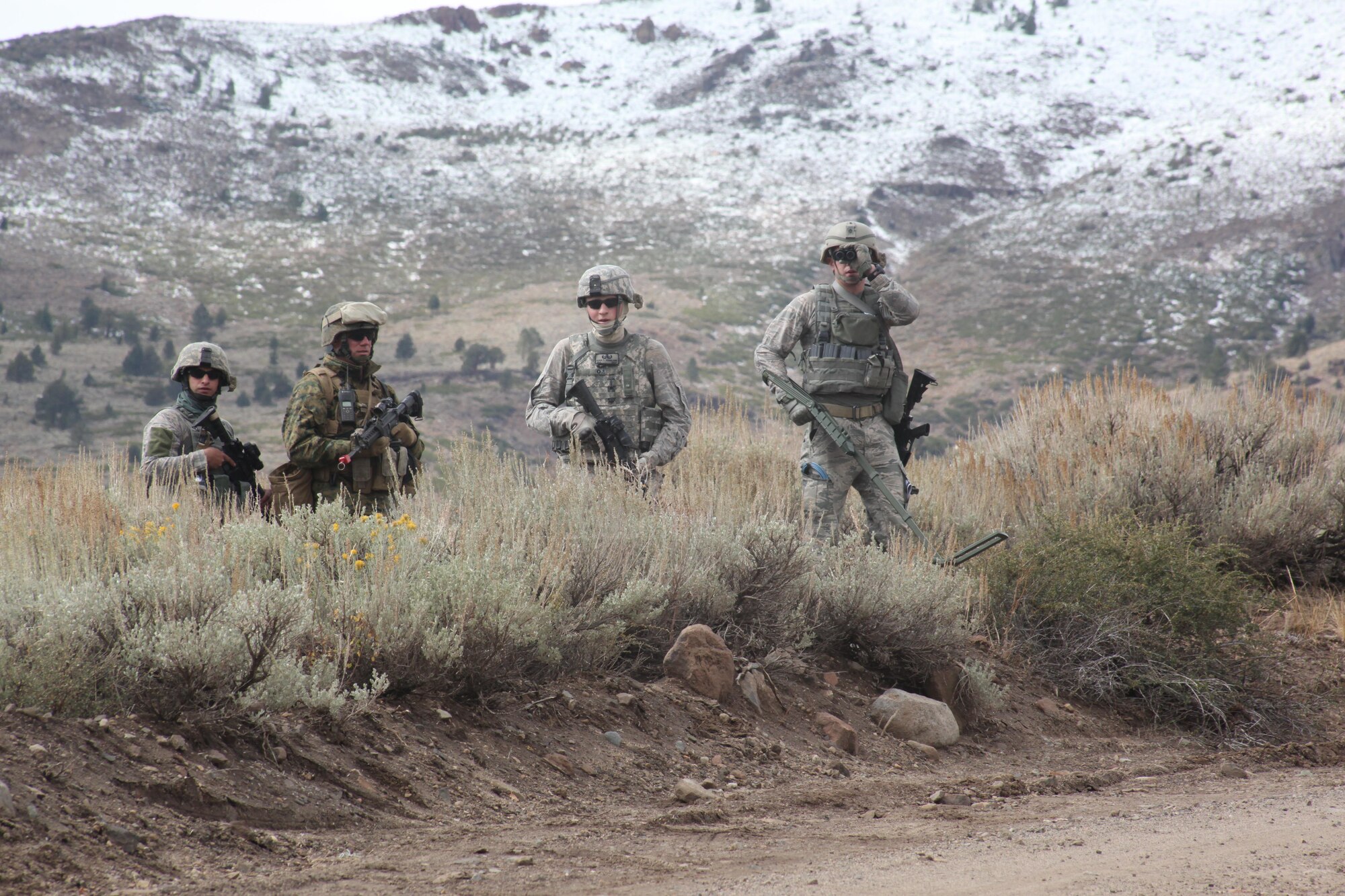 An Air Force and Marine team approaches a road where a notional improvised explosive device is believed to be planted. During the Cordon and Search exercise, role players posing as Afghan natives informed the service members of the IED Oct. 6, 2010, at the Mountain Warfare Training Center in Bridgeport, Calif.  (U.S. Marine Corps photo/Cpl. Andrew S. Avitt)