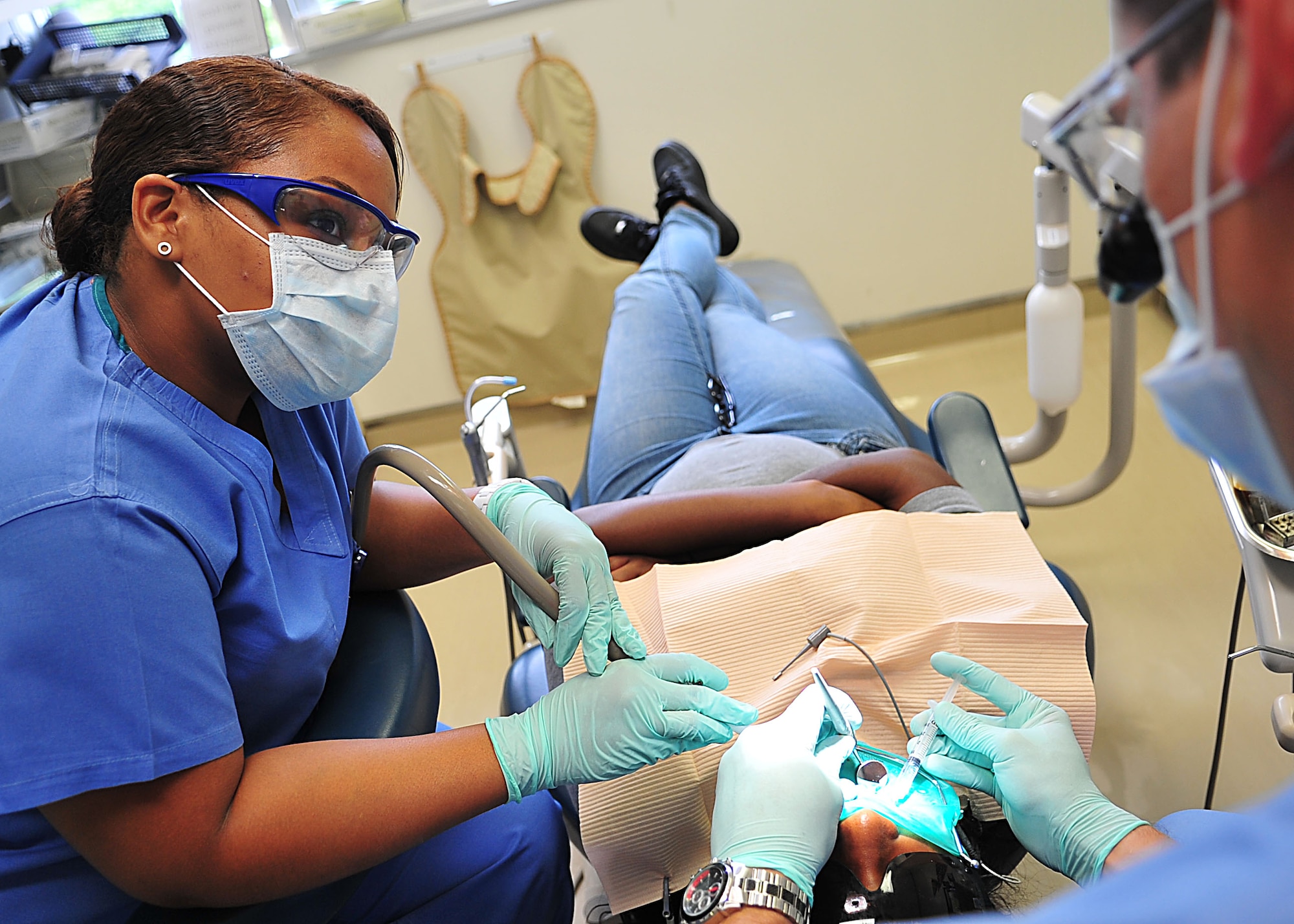 Francesca Balajadia, Red Cross volunteer, assists Dr. (Capt.) Aaron Smith during a dental procedure at the Kadena dental clinic Oct. 13. Ms. Balajadia is currently participating in the Red Cross Dental Assistant Training program which consists of two weeks of classroom training and five months of chair-side experience assisting dentists with all aspects of dental care. (U.S. Air Force photo/Staff Sgt. Alesia Goosic)