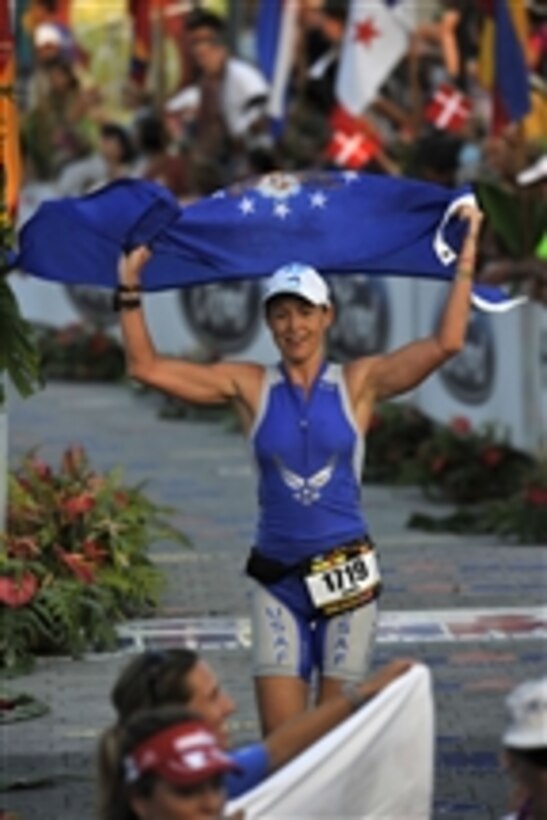 U.S. Air Force Capt. Jamie Turner, a reservist and C-17 Globemaster III aircraft pilot, waves an Air Force flag as she crosses the finish line during the Ford Iron Man World Championship in Kona-Kailua, Hawaii, on Oct. 9, 2010.  The championship triathlon consisted of a consecutive 2.4 mile swim, 112-mile bike race and 26-mile marathon.  Turner finished first in the military female division with a time of 10:48:31.  