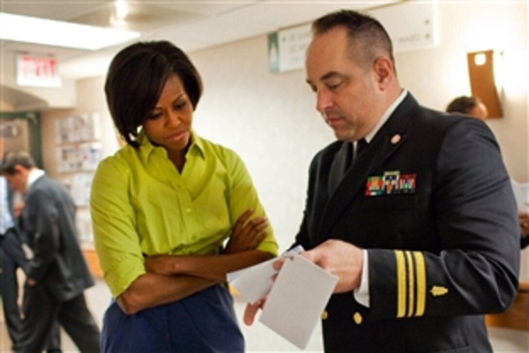 Navy Lt. Cmdr. Todd Hazlett briefs First Lady Michelle Obama before meeting with injured troops and their families at Bethesda Naval Hospital in Bethesda, Md., Oct. 12, 2010.