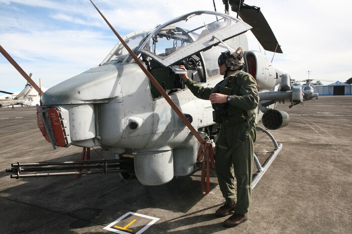 An AH-1W Super Cobra pilot assigned to Marine Medium Helicopter 262 (Reinforced), the "Flying Tigers," part of the 31st Marine Expeditionary Unit, performs a pre-flight check of his aircraft prior to take off from Clark Air Base in the Republic of the Philippines.  HMM-262 (REIN) and the 31st MEU are in the Philippines conducting bilateral training exercises designed to enhance the skills of pilots from both nations. The interoperability training increases the partner nations' abilities to respond together to real-world contingencies.