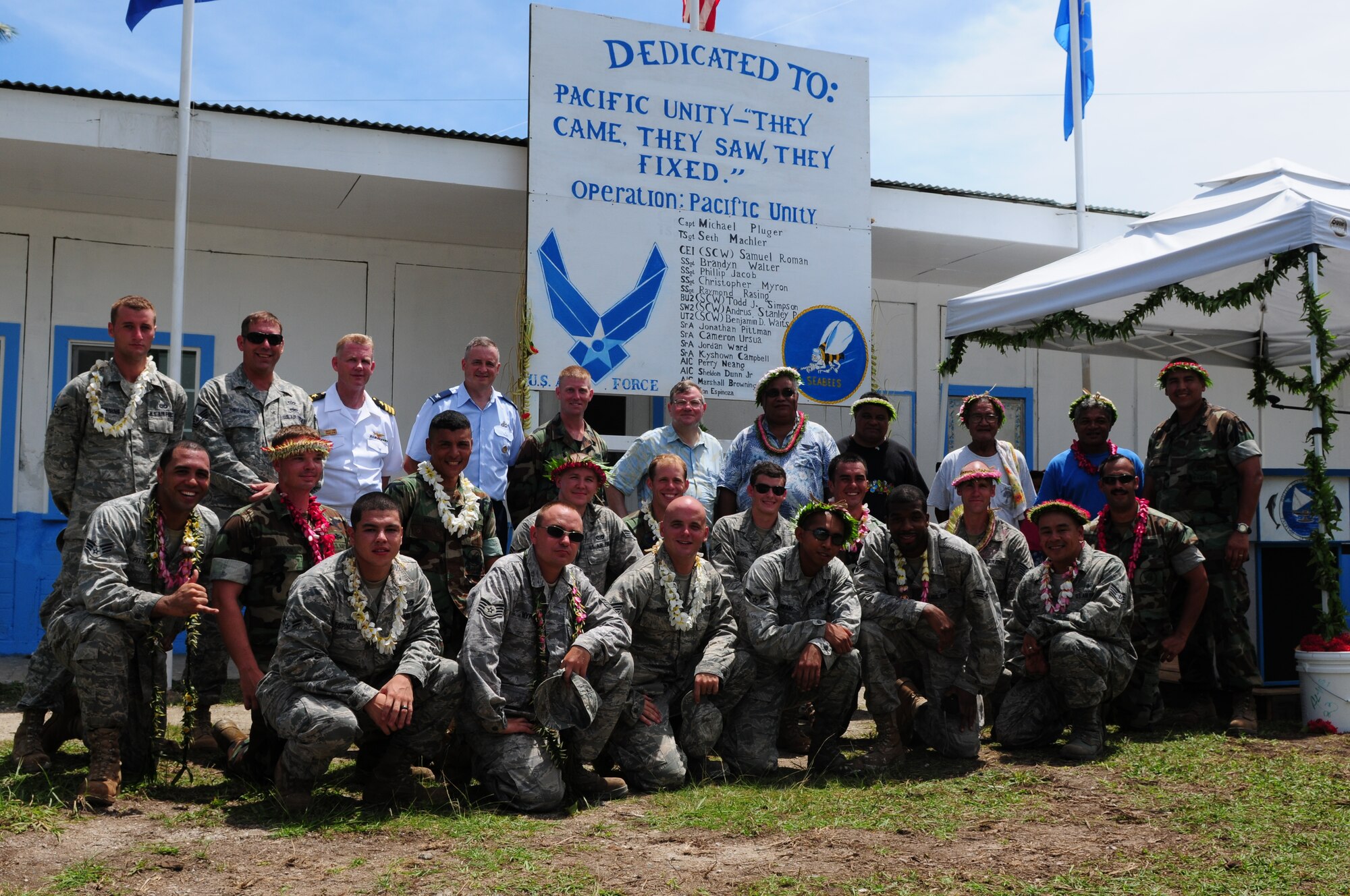 The Pacific Unity engineering team, made up of U.S. Air Force engineers from Yokota, Japan, and U.S. Navy Seabees from San Diego, Calif., gather for a group photo with  U.S. Ambassador Peter A. Praha and community leaders after the dedication ceremony on Sep. 22, 2010.  Pacific Unity 2010 is a humanitarian civil engineering effort in which 18 civil engineers completely rebuilt, remodeled and repainted a high school on a remote island in Micronesia. (U.S. Air Force Photo/Master Sgt. Victoria Meyer)