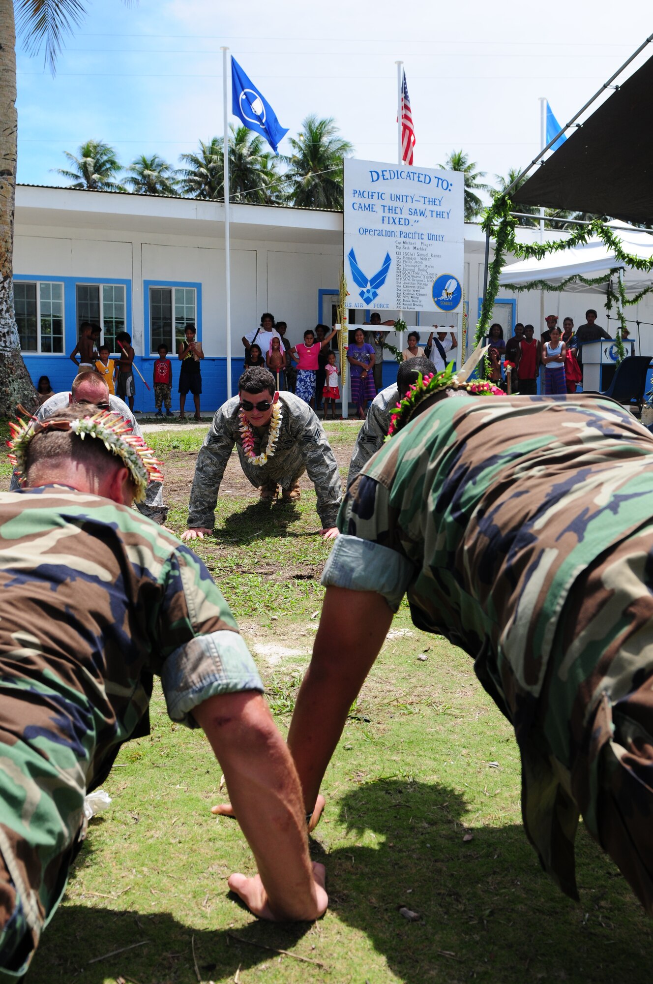 A civil engineering team, made up of U.S. Air Force civil engineers from Yokota, Japan, and U.S. Navy Seabees from San Diego, Calif., gather for their last tribute to the islanders of Falalop, Yap, Federated States of Micronesia, as they perform push-ups as a group during Pacific Unity 2010, on Sep. 22, 2010. Pacific Unity 2010 is a humanitarian civil engineering effort in which civil engineers completely rebuilt, remodeled and repainted a high school on a remote island in Micronesia. (U.S. Air Force Photo/Master Sgt. Victoria Meyer)