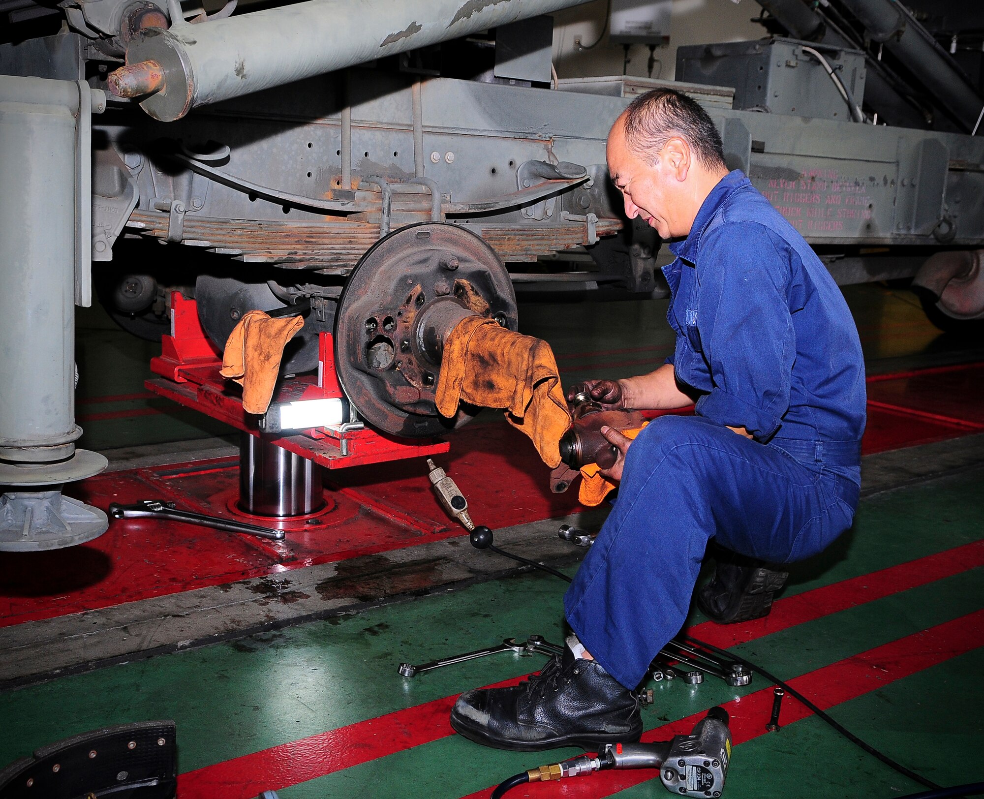 YOKOTA AIR BASE, Japan-- Mr. Yoshinori Aoki, 374th Logistics Readiness Squadron, is in the process of working on a rear wheel assembly Oct. 13.  The 374th LRS works to maintain duty and combat skills proficiency to meet 374 Airlift Wing, combatant commander and national security objectives. (U.S. Air Force photo/Staff Sgt. Stacy Moless)