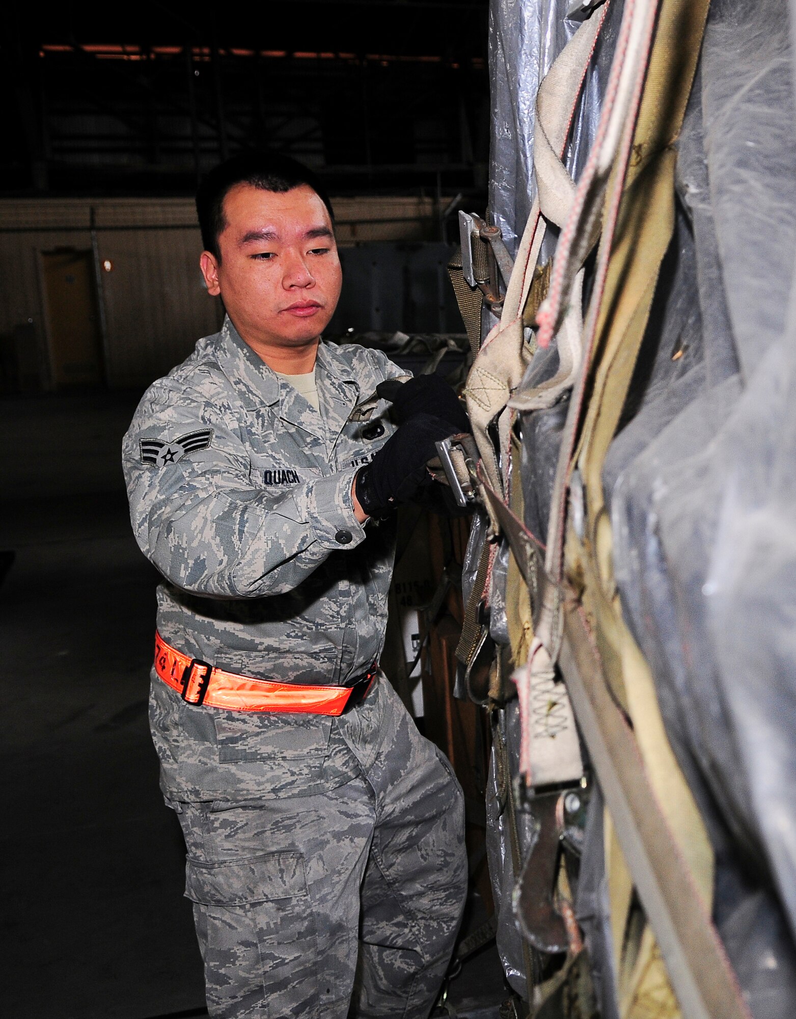 YOKOTA AIR BASE, Japan -- Staff Sgt. Stanley Quach, 374th Logistics Readiness Squadron is tightening down cargo straps for an aircraft pallet, Oct. 13.  The 374th LRS works to maintain duty and combat skills proficiency on Yokota Air Base.(U.S. Air Force photo/Staff Sgt. Stacy Moless)