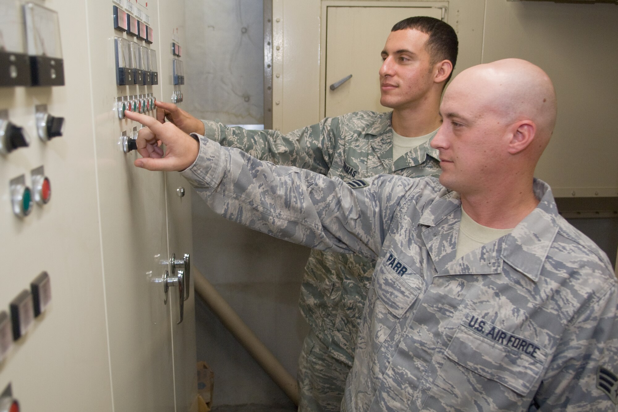 YOKOTA AIR BASE, Japan -- Senior Airman David Parr (front) and Senior Airman Christopher Thomas (back), both from the 374th Civil Engineer Squadron HVAC technicians, inspect a heating and cooling control panel here Oct. 14. The HVAC shop maintains the heating and cooling systems for over 1,000 facilities around Yokota; the testing marks the beginning of the No Heat, No Cool season.  (U.S. Air Force photo/Osakabe Yasuo)