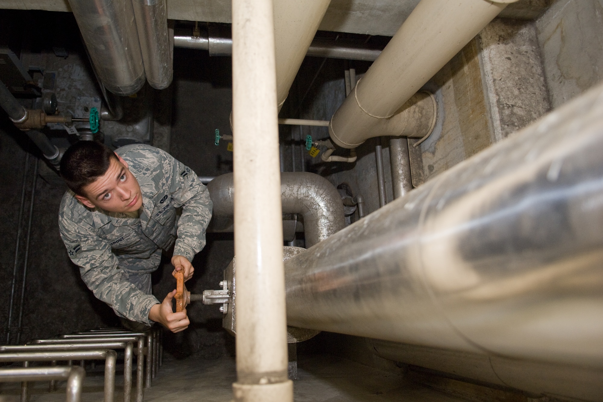 YOKOTA AIR BASE, Japan -- Airman 1st Class Jacob Trout, 374th Civil Engineer Squadron heating, ventilation and air conditioning technician, checks the flow of underground heating valves before operating the system here Oct. 14. The HVAC shop maintains the heating and cooling systems for over 1,000 facilities.  (U.S. Air Force photo/Osakabe Yasuo)  