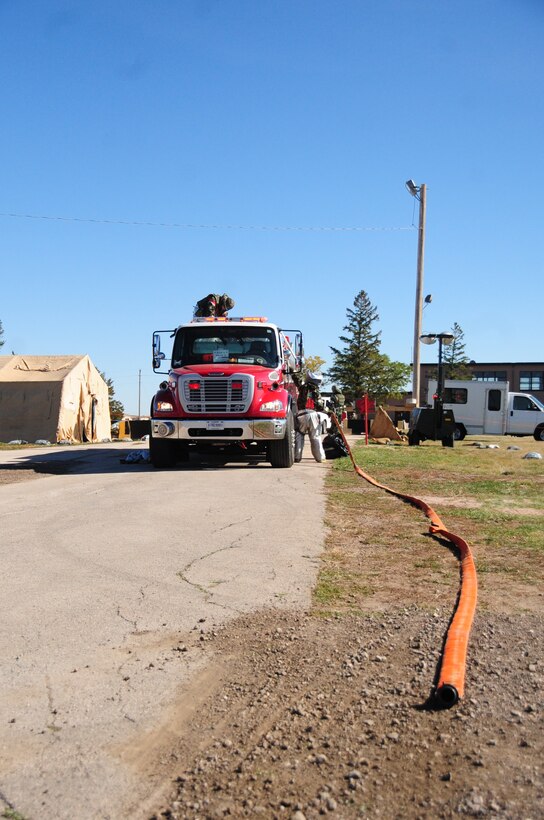 ELLSWORTH AIR FORCE BASE, S.D. - 28th Civil Engineer Squadron firefighters coil up their hoses after a simulated fire at Camp Lancer during a Phase II Operational Readiness Inspection, Oct. 14.  Ellsworth firefighters respond to a number of simulations, including, building fires, medical emergencies and flightline incidents. (U.S. Air Force photo/Airman 1st Class Anthony Sanchelli)